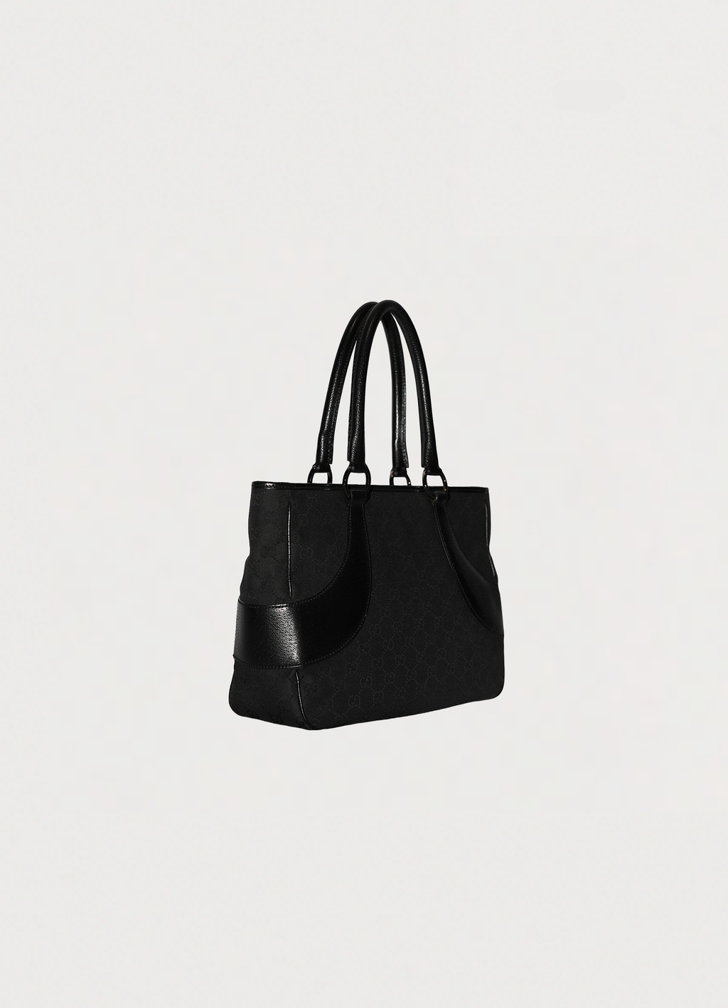 Gucci GG Canvas Tote Bag in black canvas with leather trim showing angled side