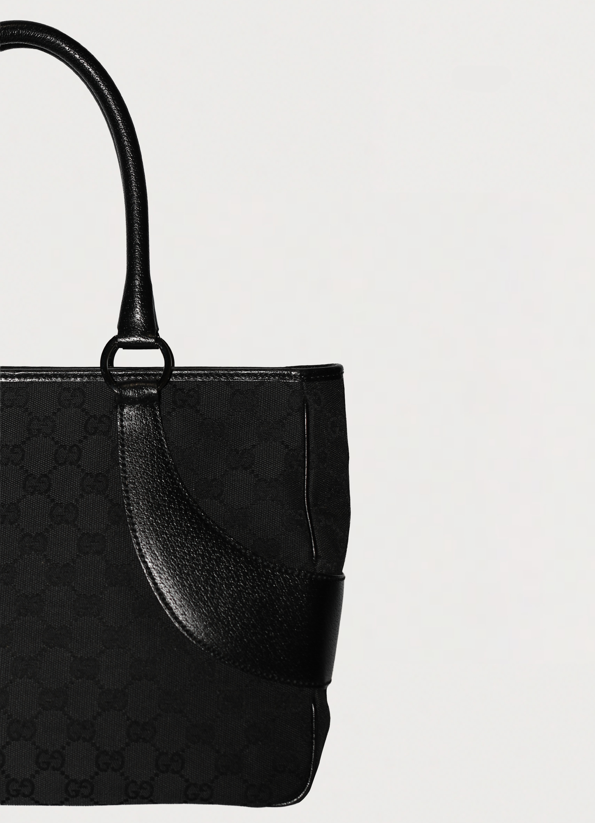 Gucci GG Canvas Tote Bag in black canvas with leather trim showing close up of left side