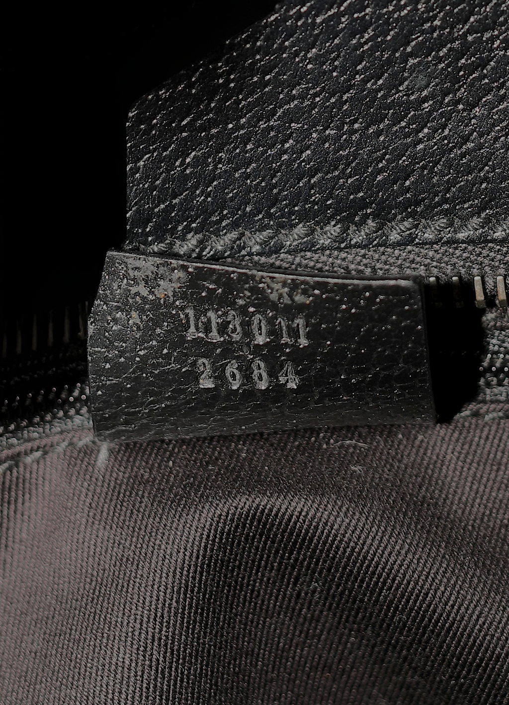 Gucci GG Canvas Tote Bag in black canvas with leather trim showing close up of serial number tag