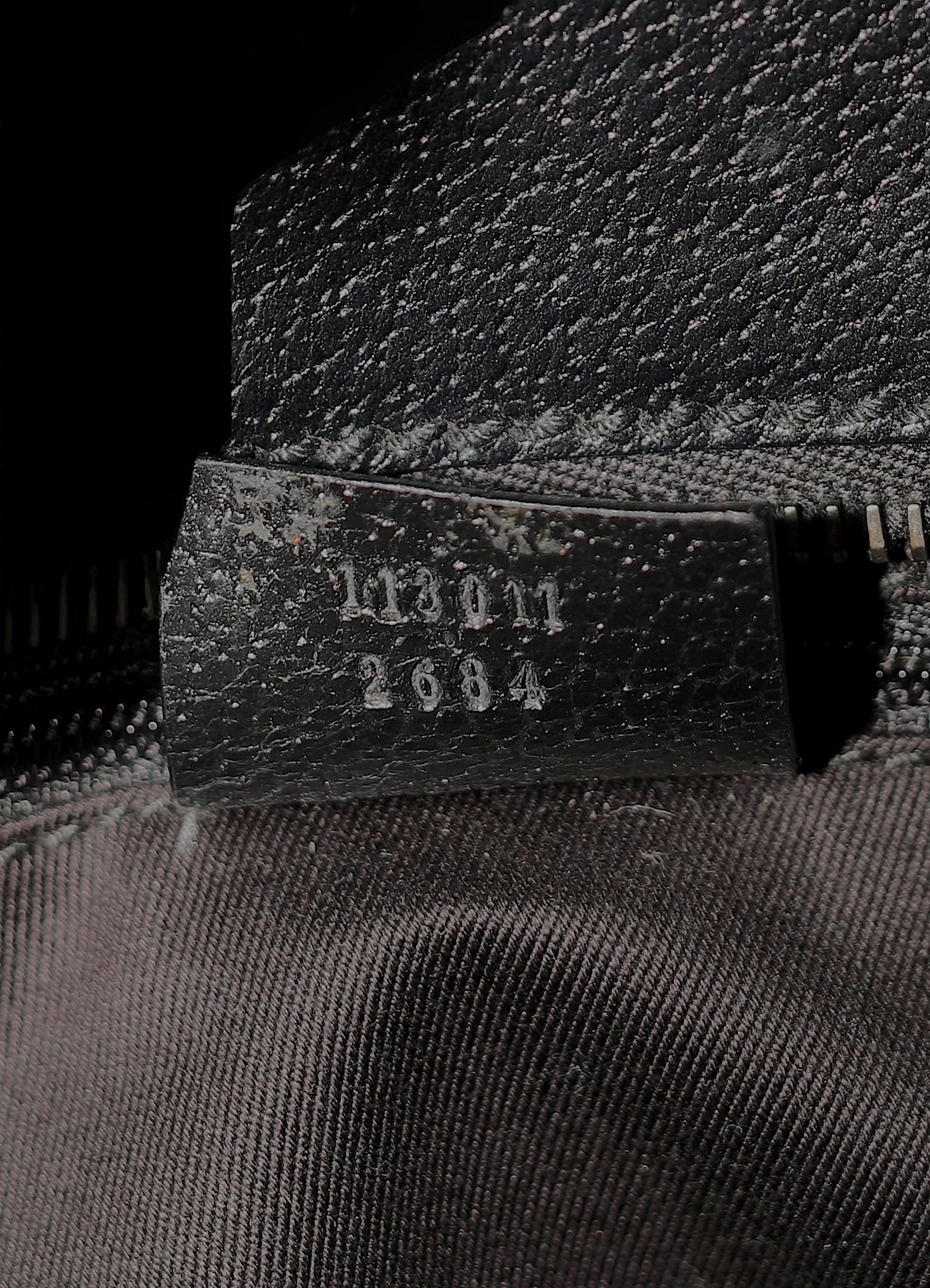 Gucci GG Canvas Tote Bag in black canvas with leather trim showing close up of serial number tag