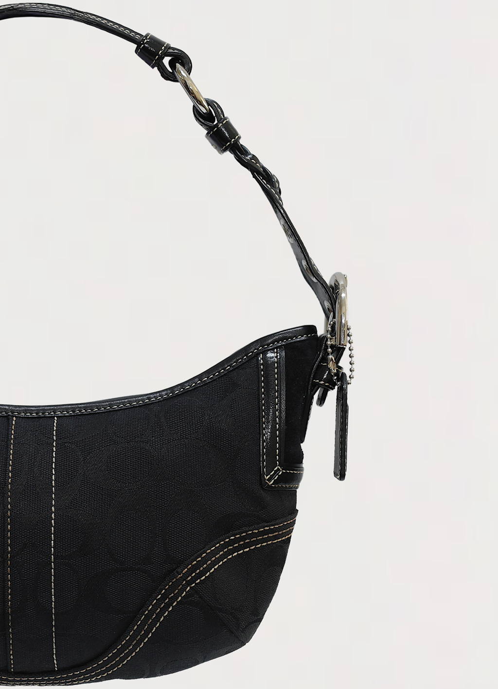 Vintage Coach Soho hobo bag in black signature canvas with leather trim showing close up of left side