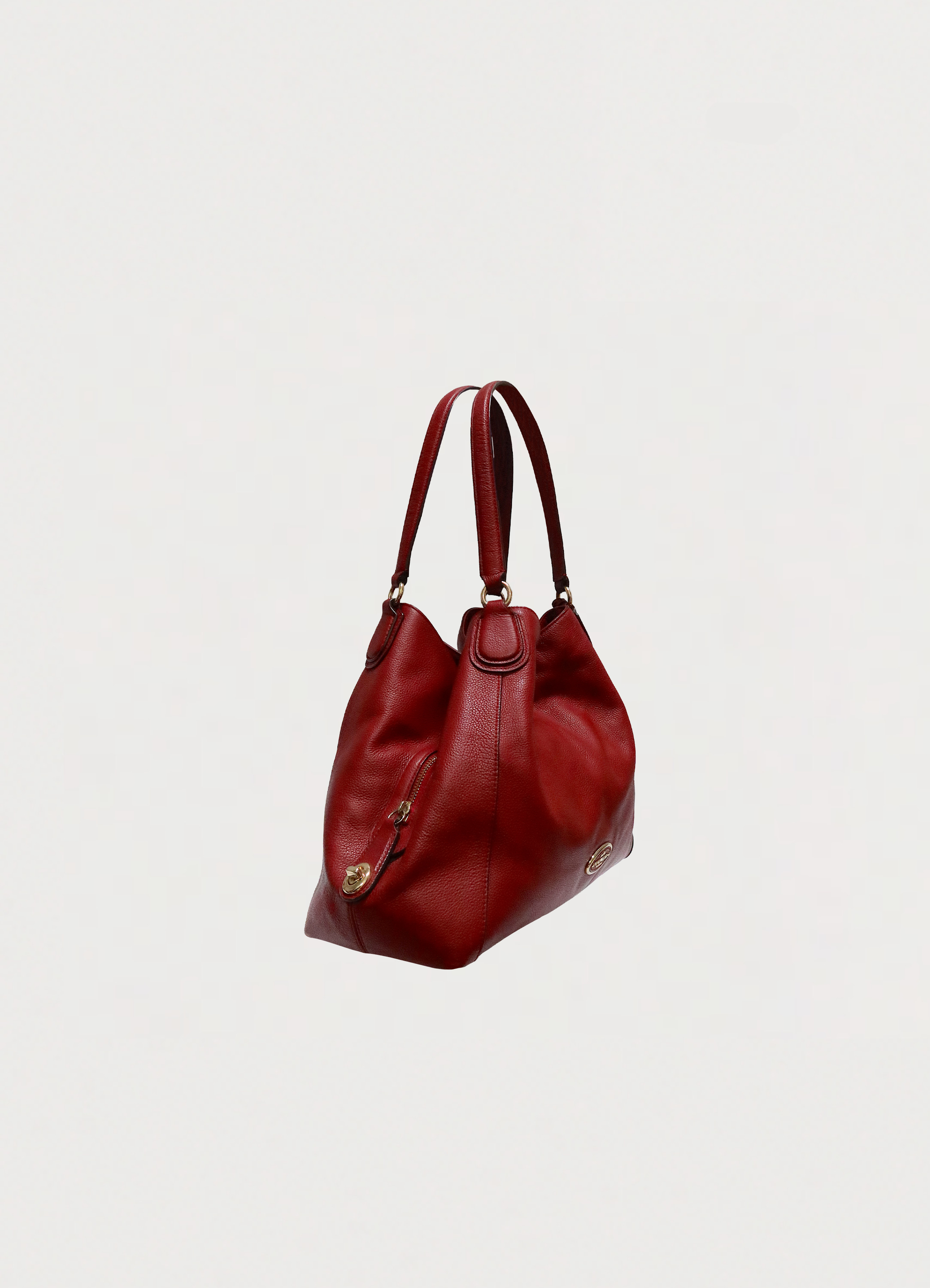 Angled view of Coach Edie 31 red leather bag showing shape