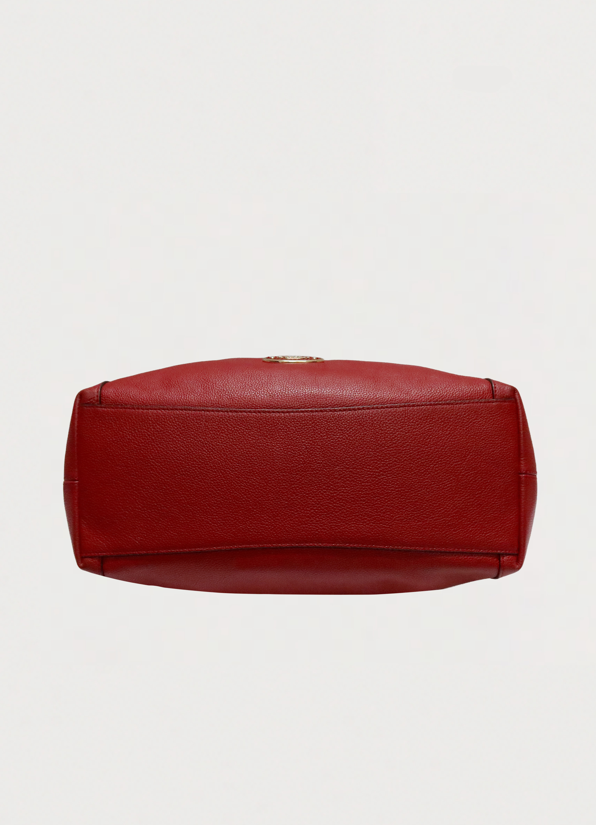 Base view of red Coach Edie 31 shoulder bag showing structured bottom