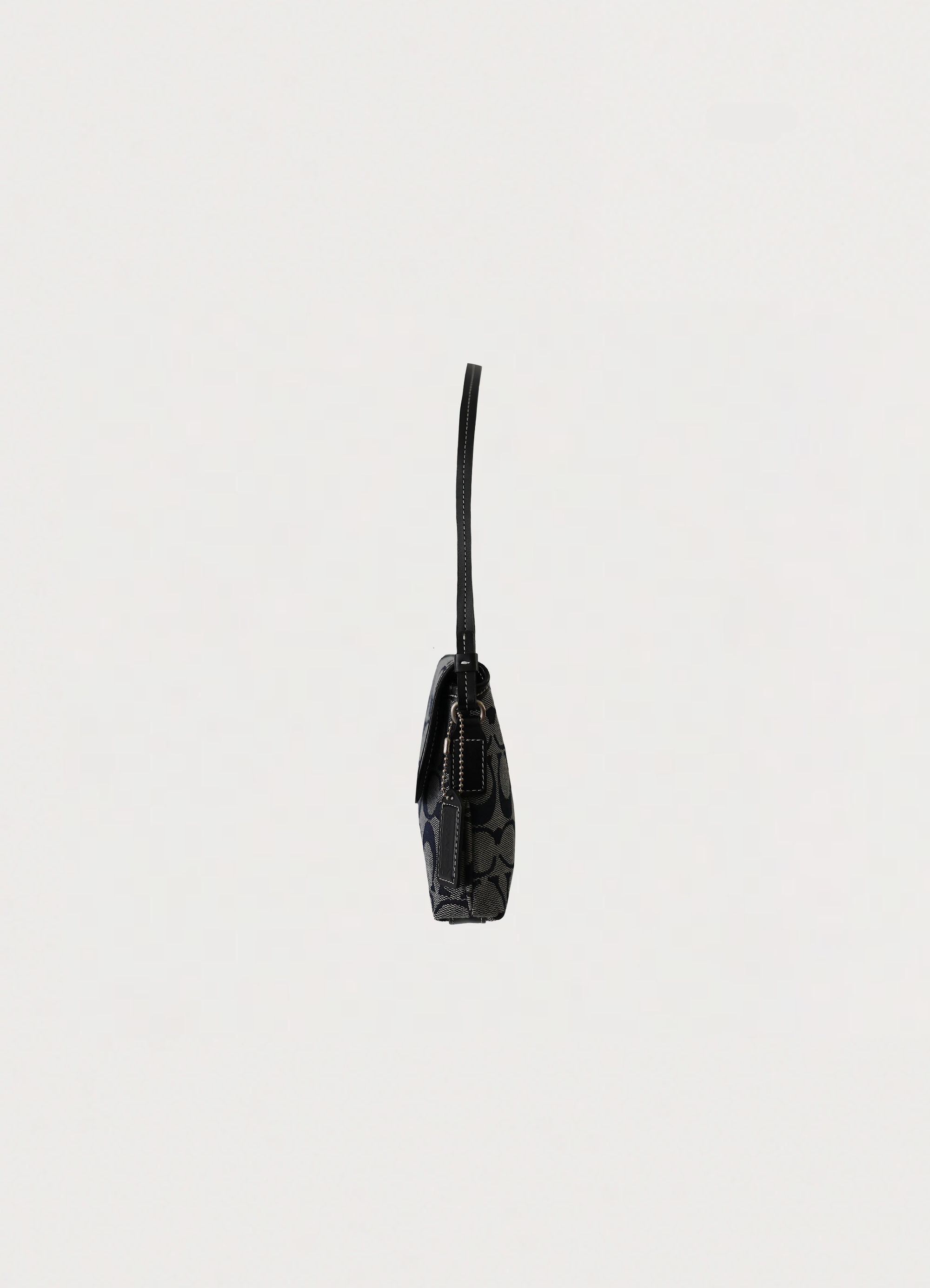 Left side profile of black and grey Coach signature demi shoulder bag