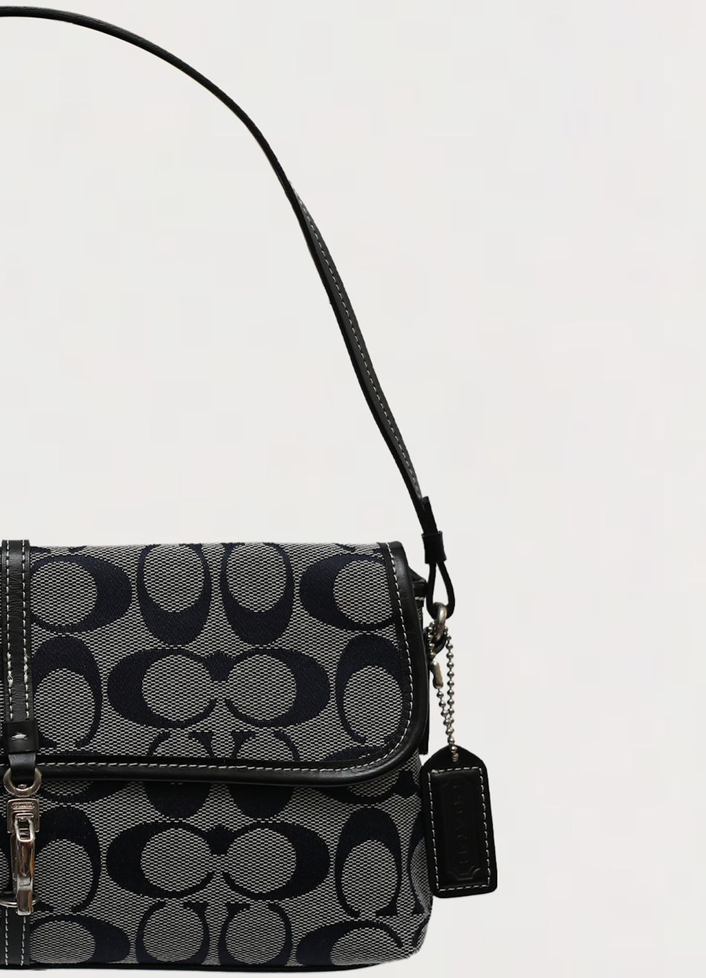 Close up of the slim black leather shoulder strap and hardware on the Coach demi bag