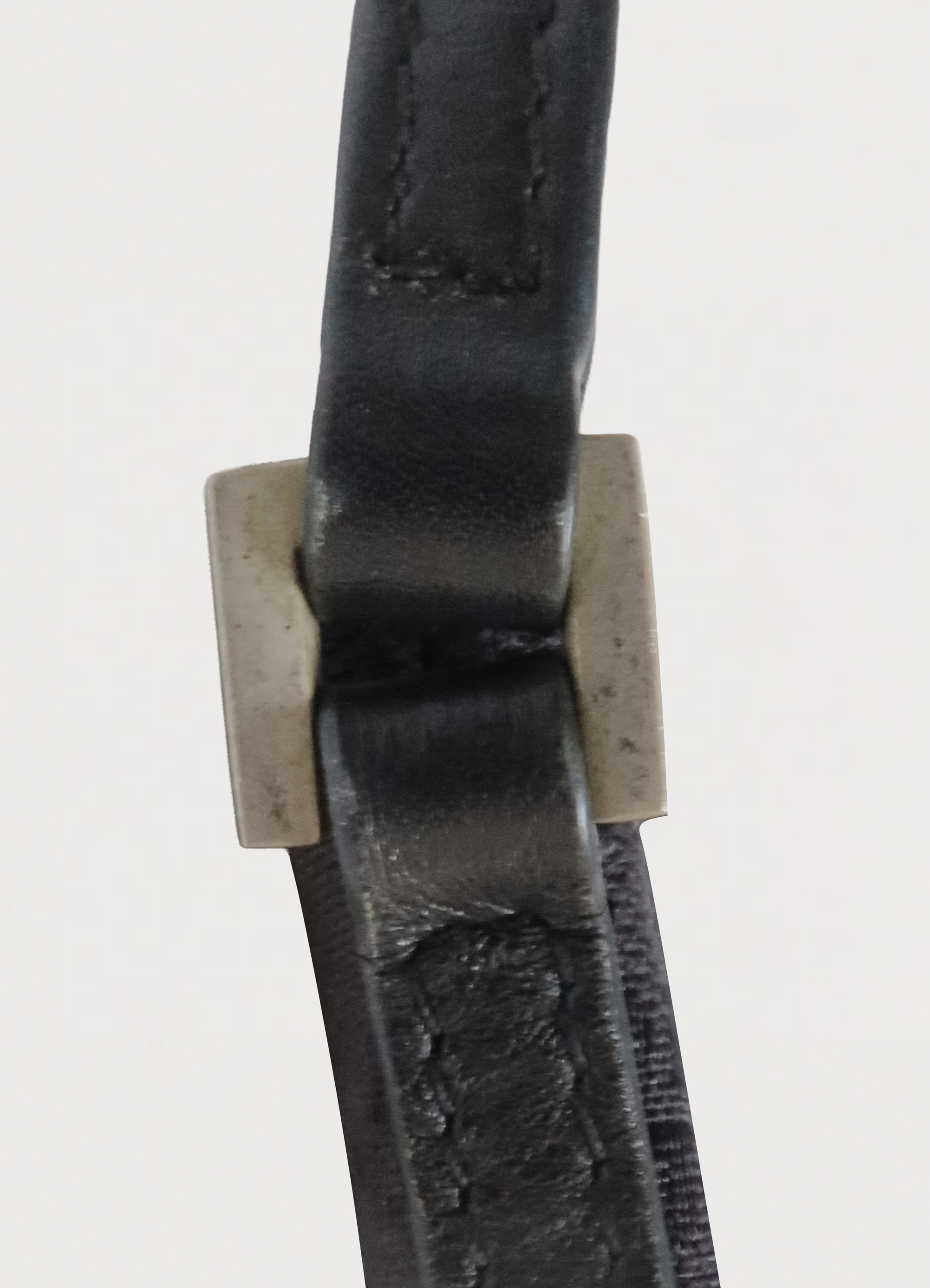 Detail shot of the black leather shoulder strap and square silver-tone hardware