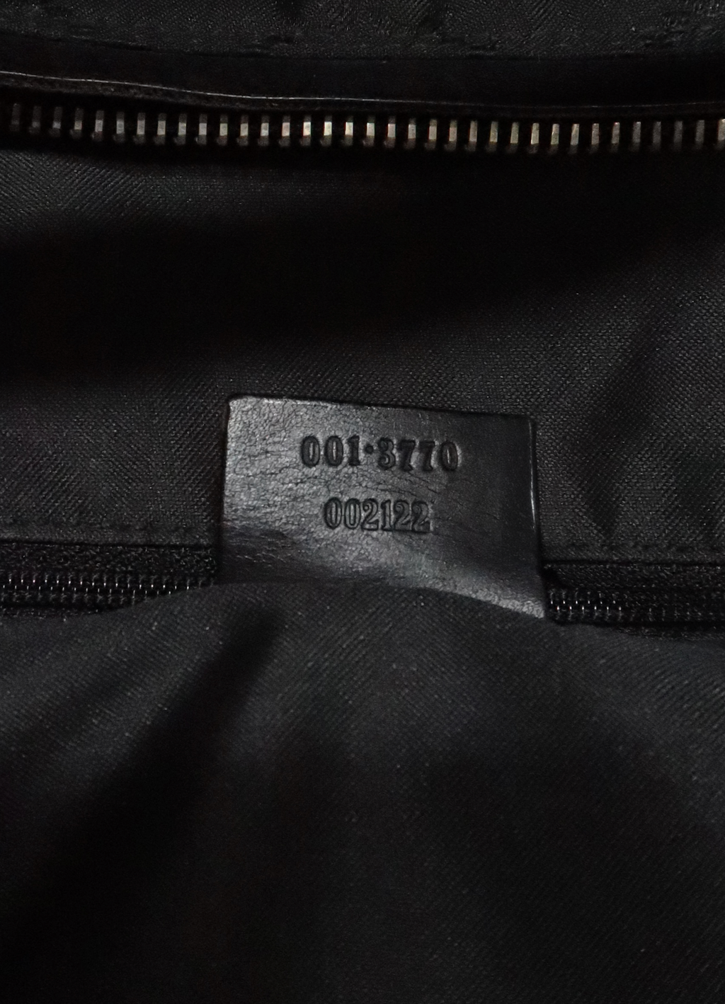 Underside of interior leather tab showing Gucci serial number 001-3770
