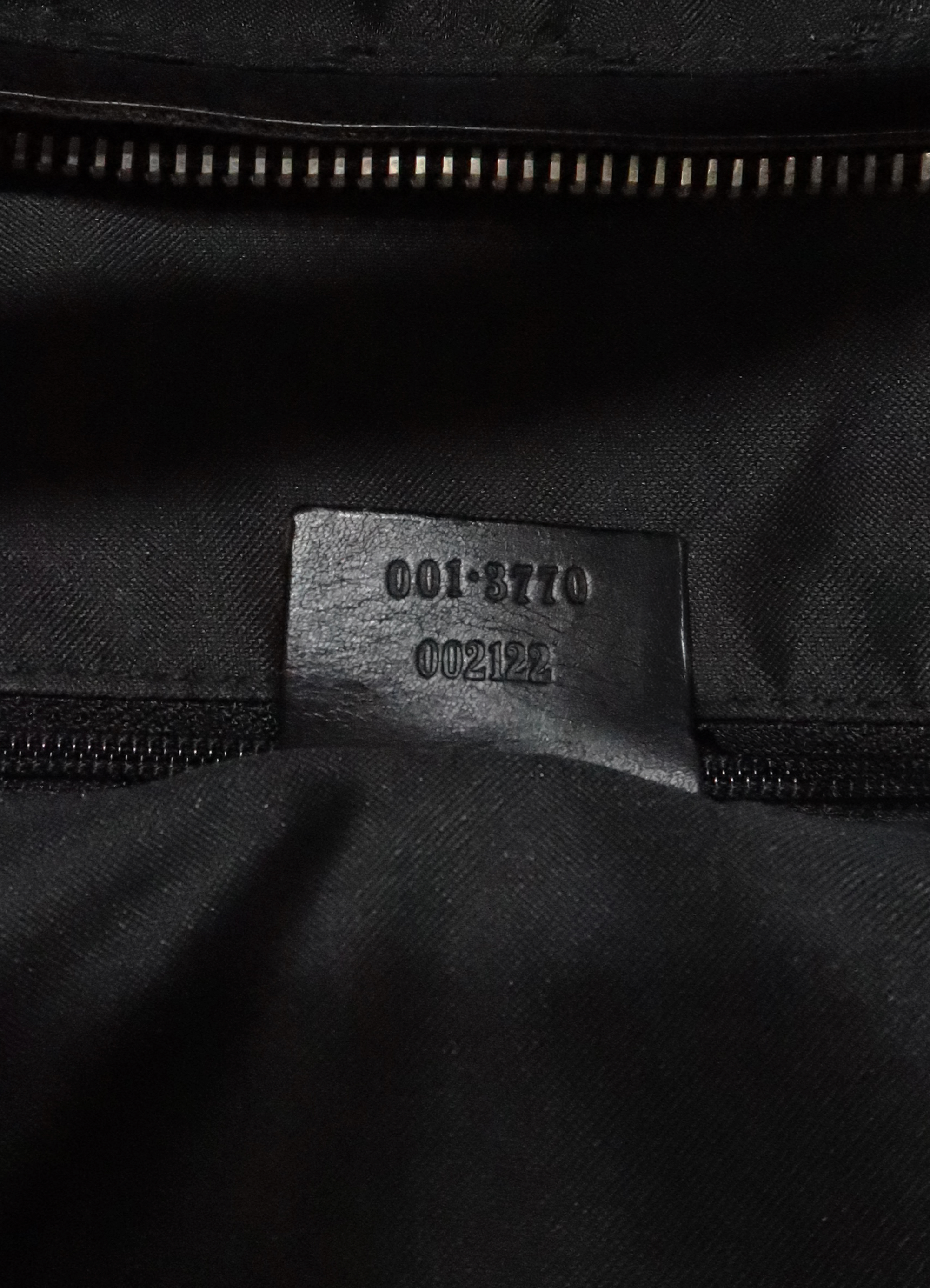 Underside of interior leather tab showing Gucci serial number 001-3770