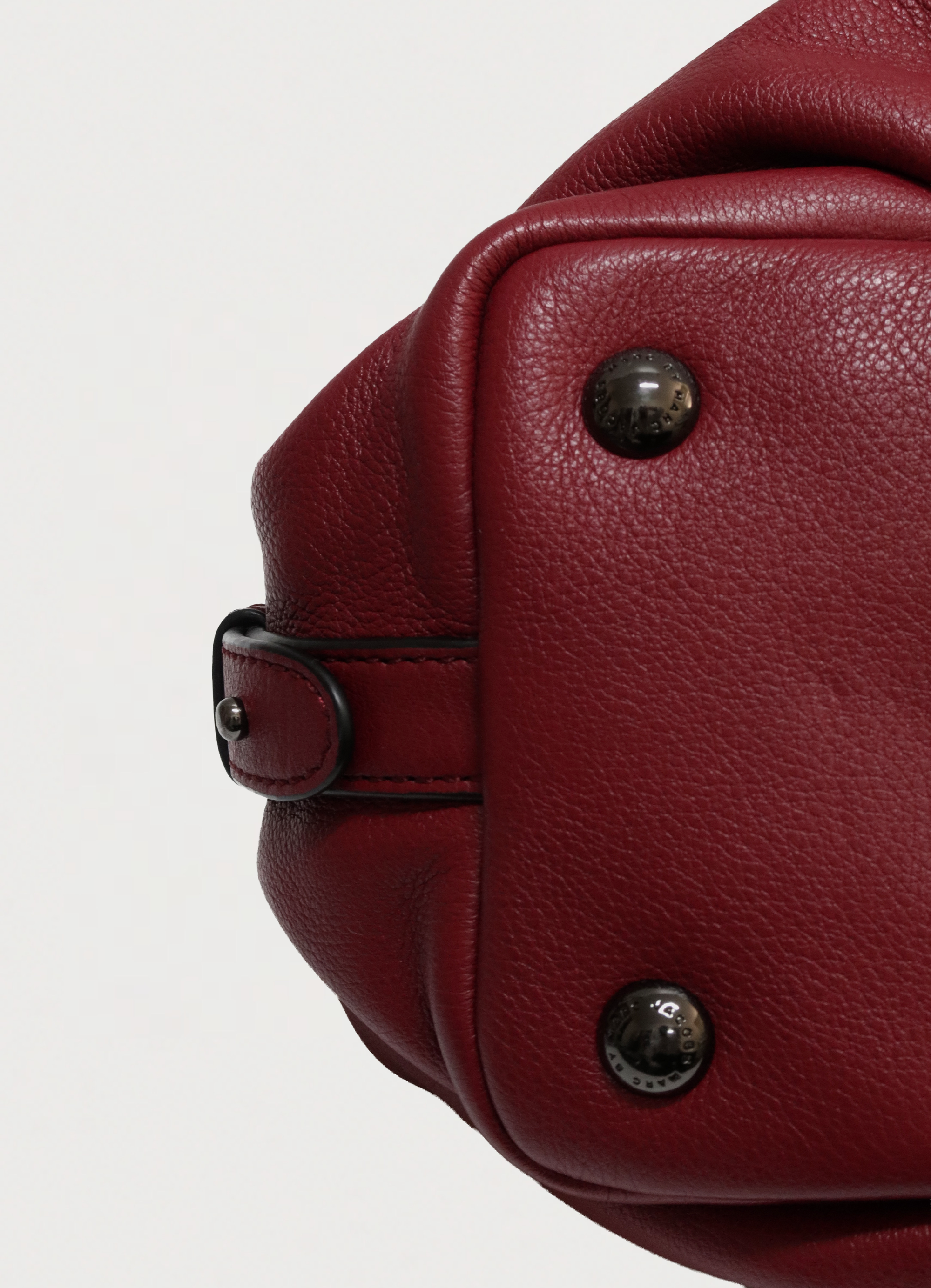 Close up of bottom corner and leather texture on Marc Jacobs satchel showing bag studs