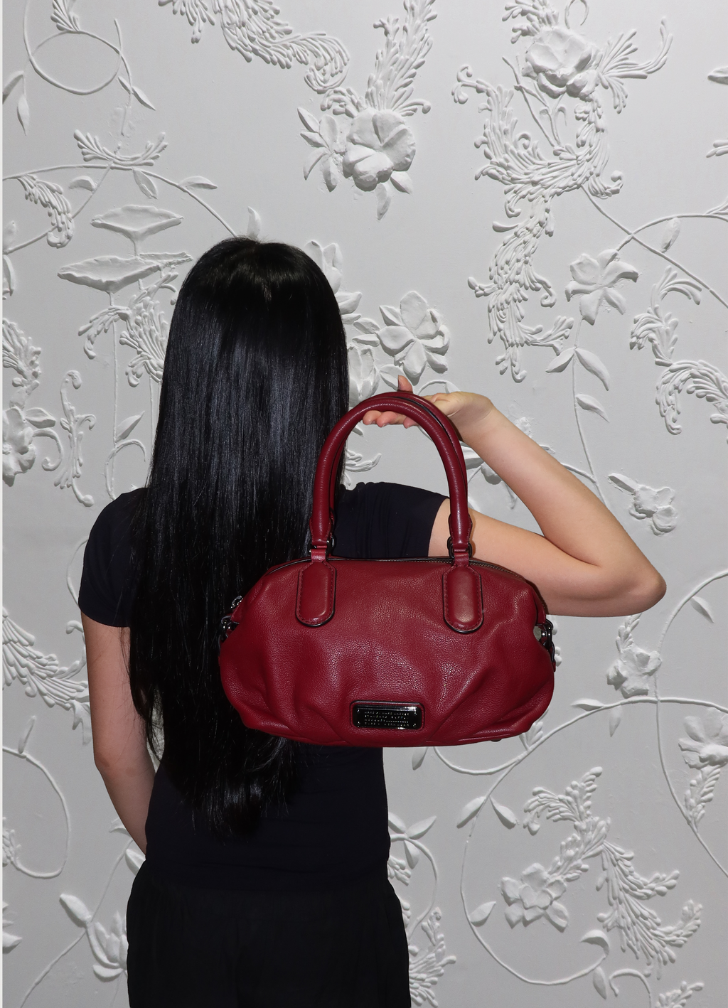 Red Marc Jacobs satchel bag shown on model for scale 