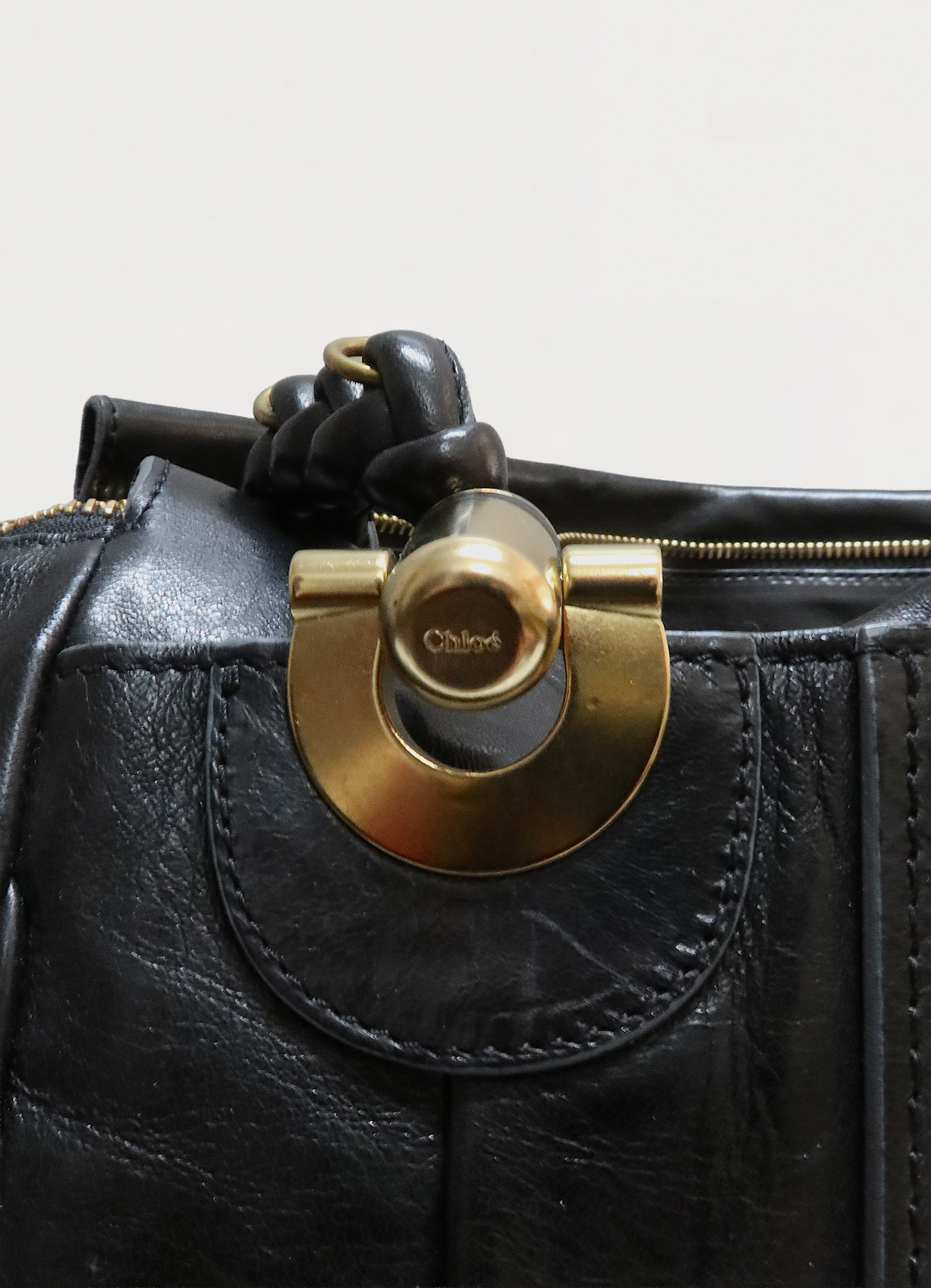 Vintage Chloe Heloise tote bag in black leather showing detail of the heavy brass rings and leather knot attachment 