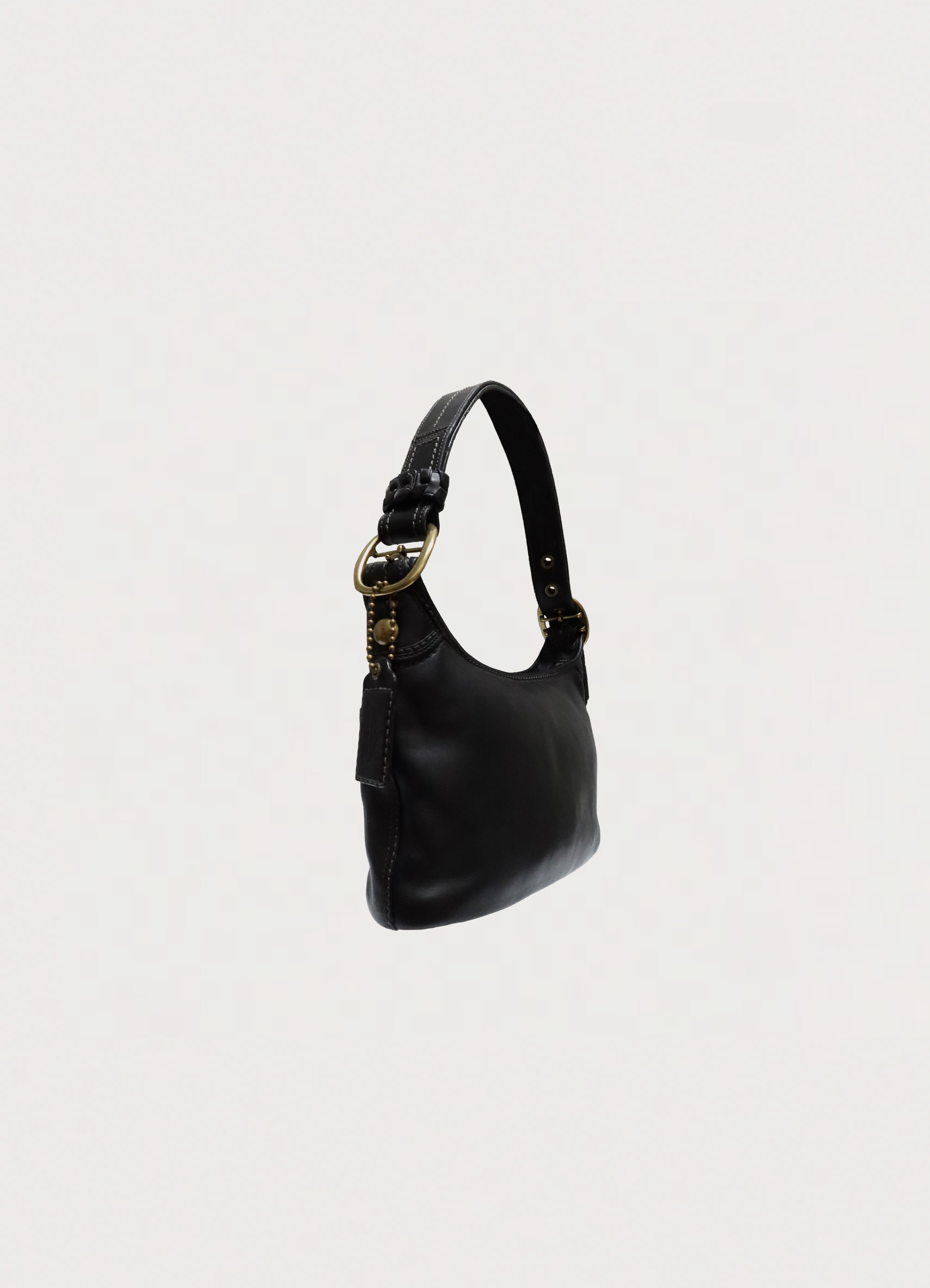 Angled view of black Coach Bleecker leather bag showing the curved hobo silhouette
