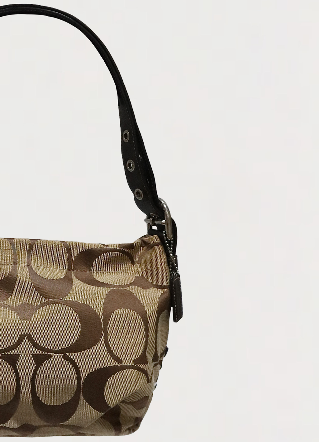 Close up of the brown leather strap and silver-tone hardware on Coach Bleecker bag
