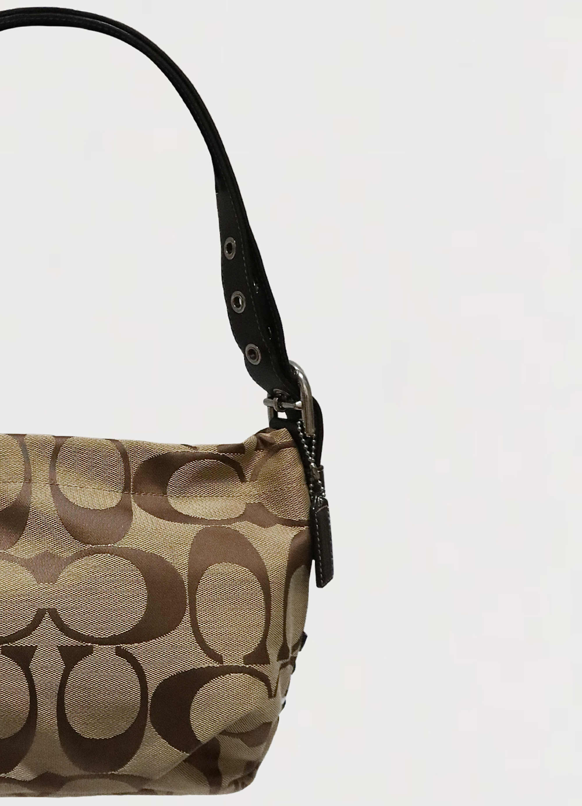 Close up of the brown leather strap and silver-tone hardware on Coach Bleecker bag