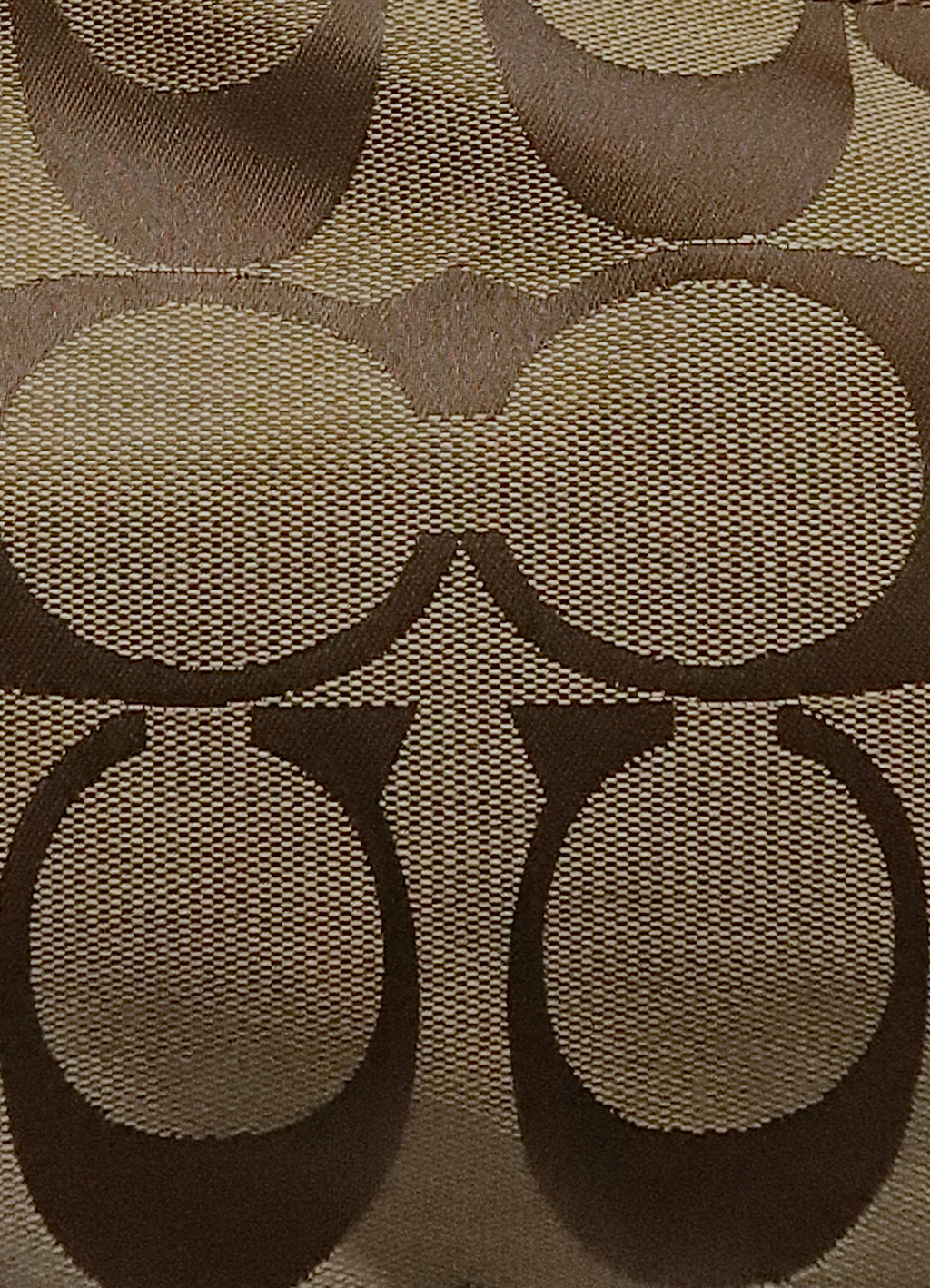 Macro shot of authentic khaki Coach signature "C" jacquard canvas