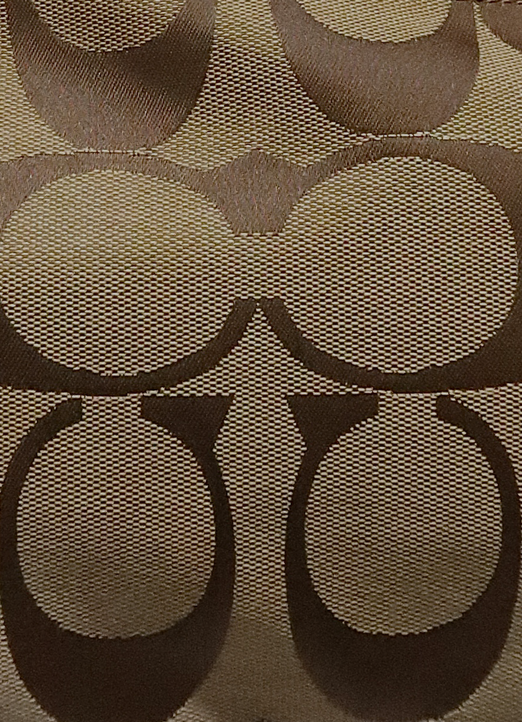 Macro shot of authentic khaki Coach signature "C" jacquard canvas