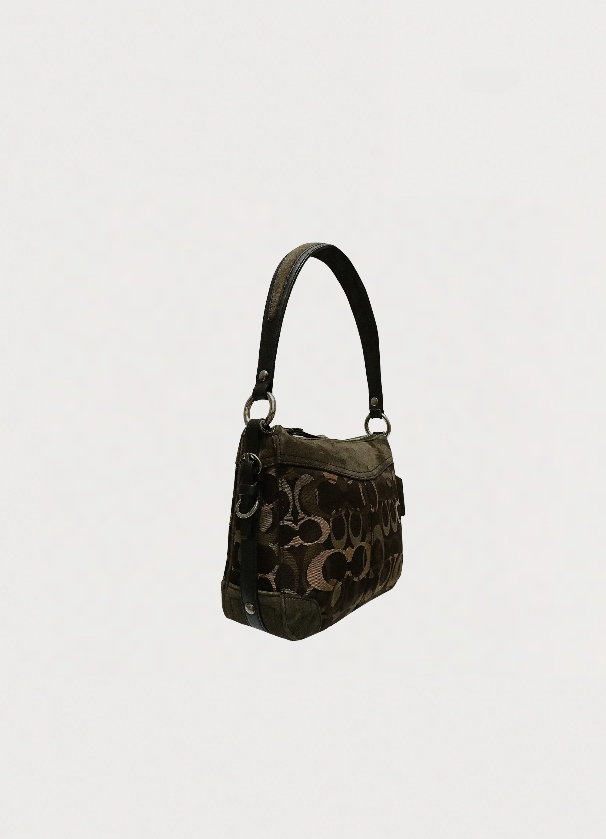 Angled side view of Coach Chelsea optic bag showing suede trim and canvas texture