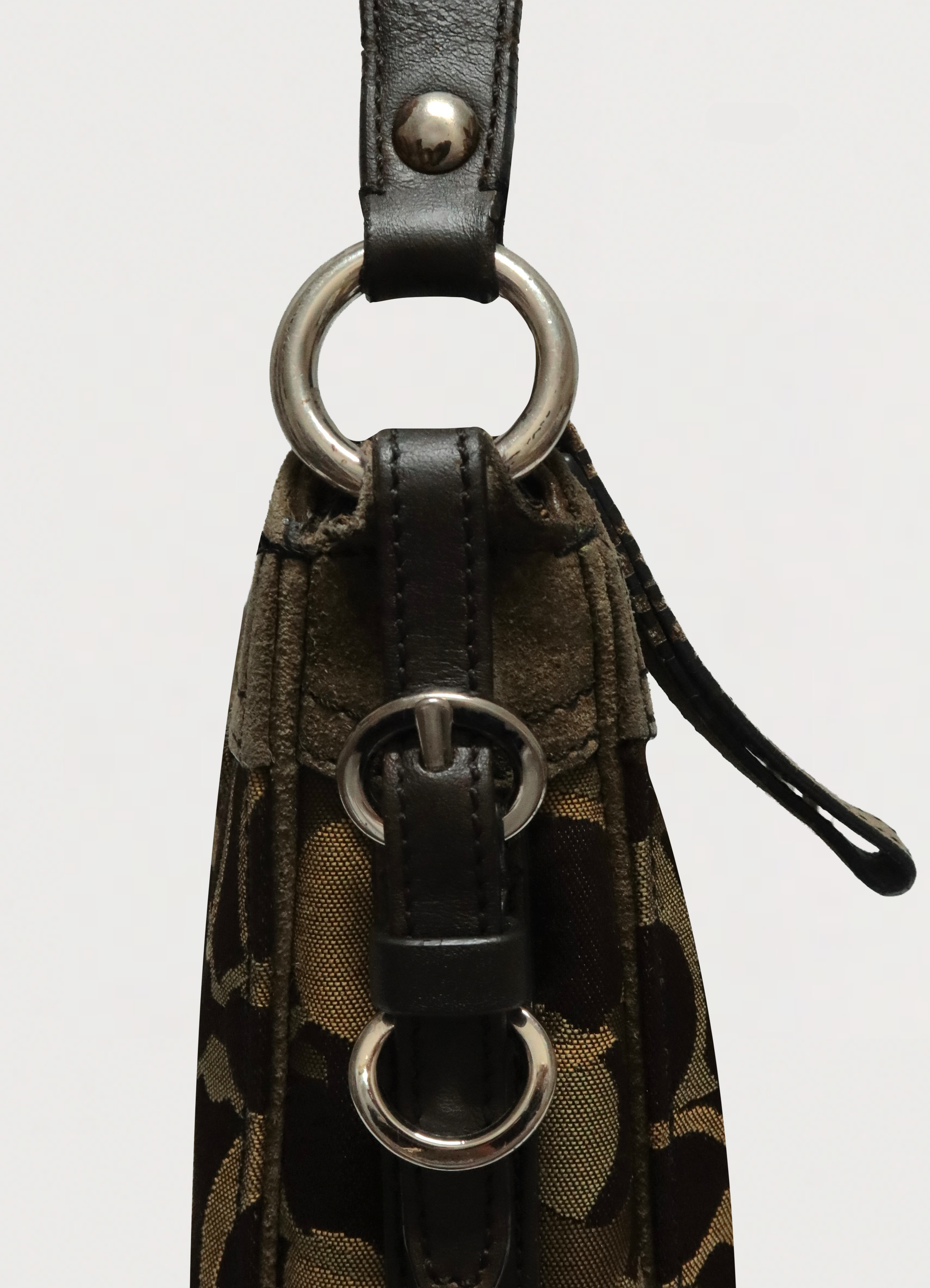 Detail of the silver-tone buckle hardware and olive leather trim on the Coach strap