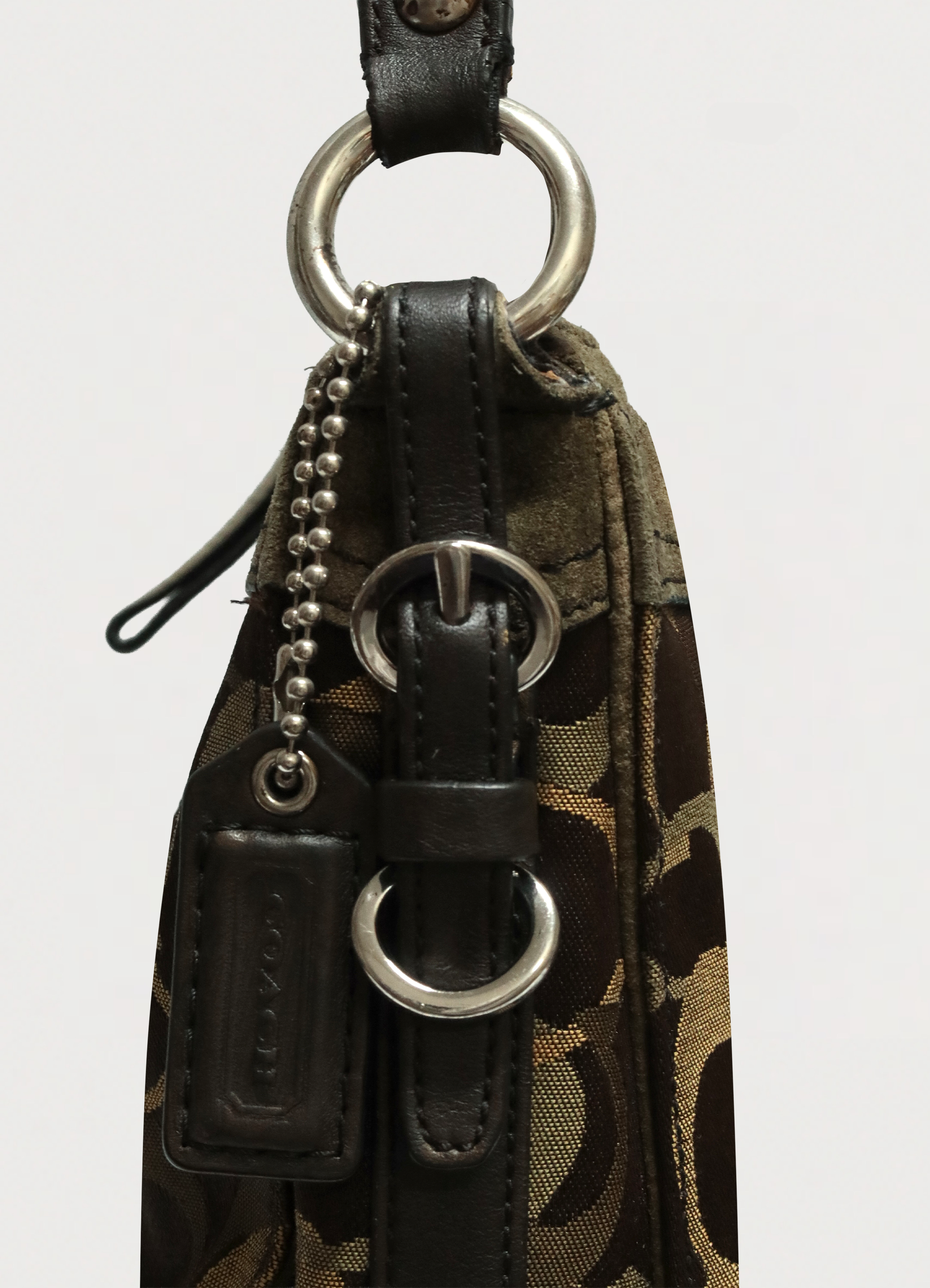 Detail of the silver-tone buckle hardware and olive leather trim on the Coach strap