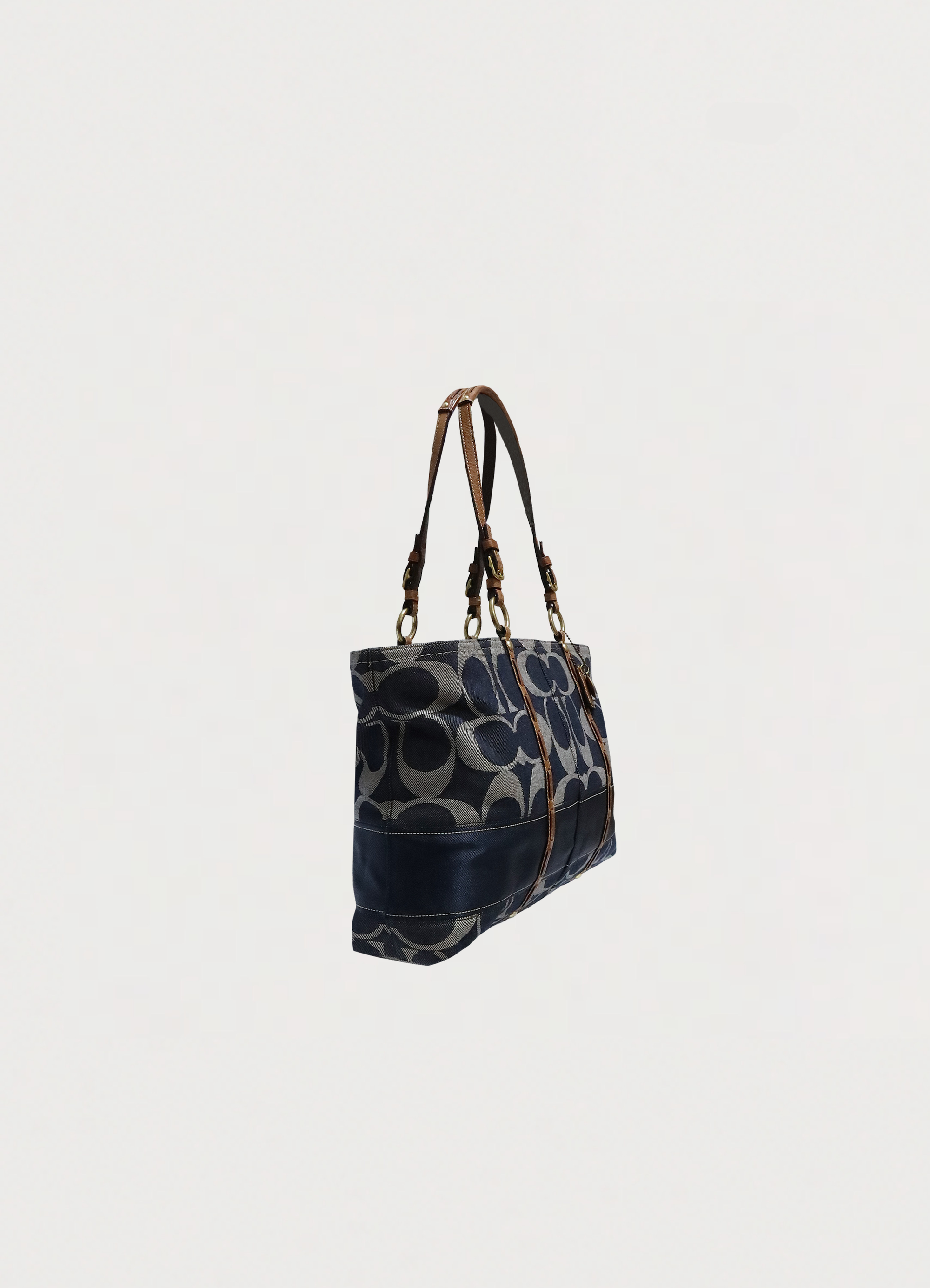 Angled view of Coach denim signature tote showing bag structure