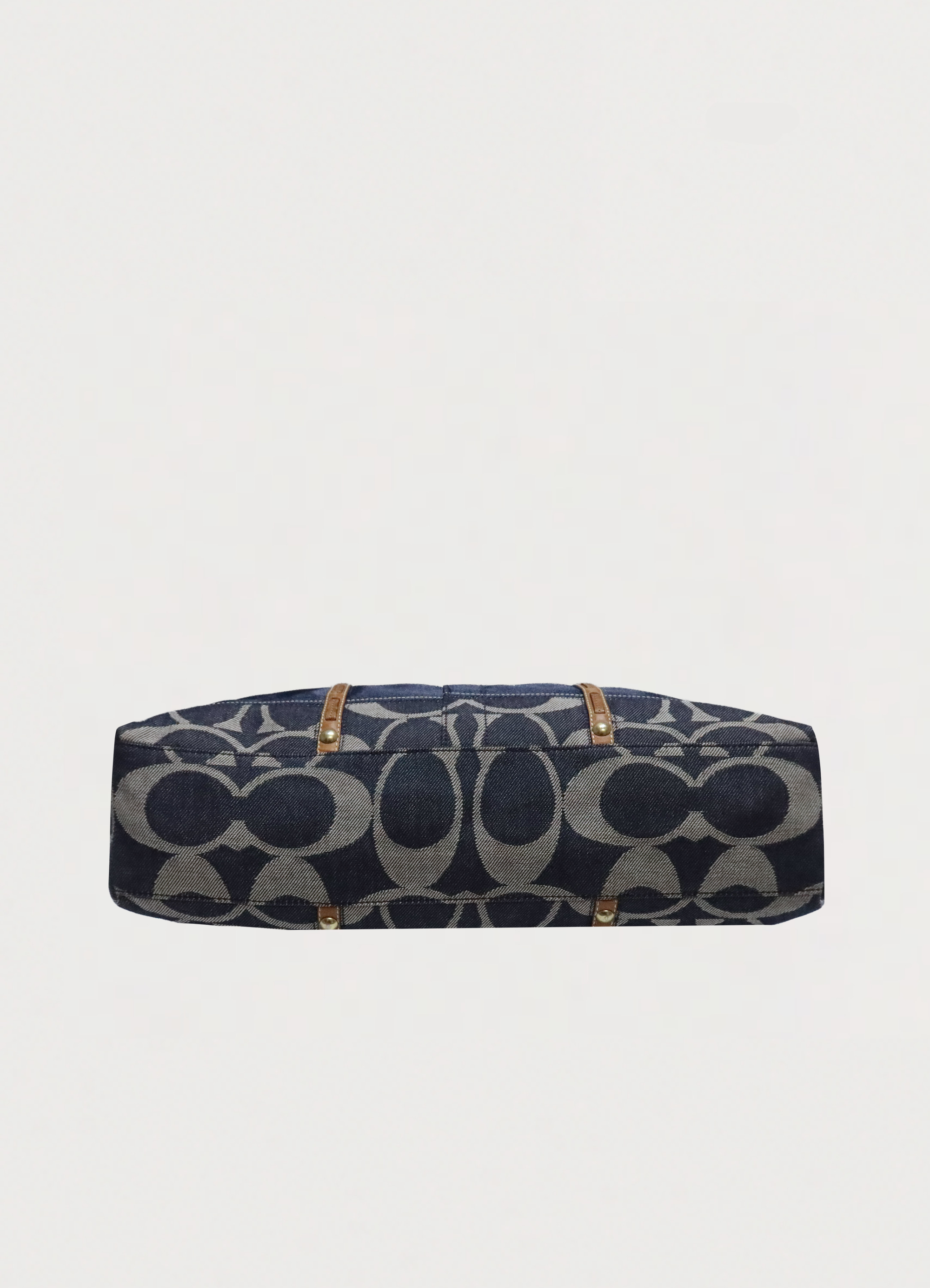 Base view of denim Coach Legacy tote bag showing signature canvas bottom