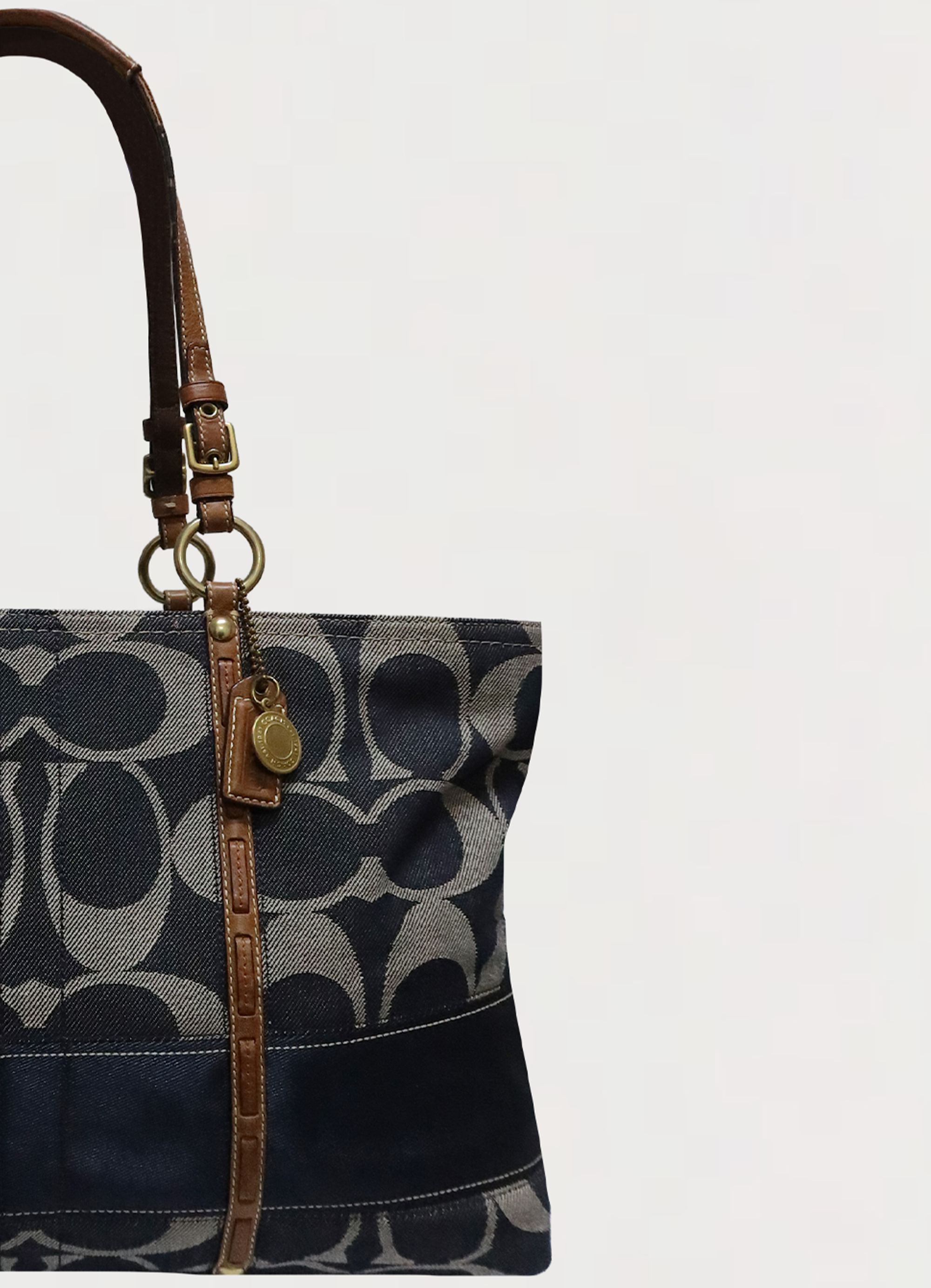 Close up of leather trim and denim canvas on the front of the Coach Legacy tote