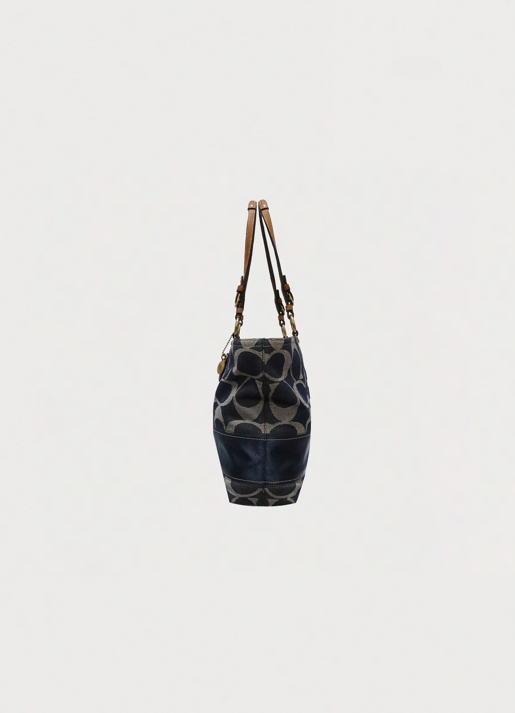 Left side profile of blue denim Coach Legacy tote bag