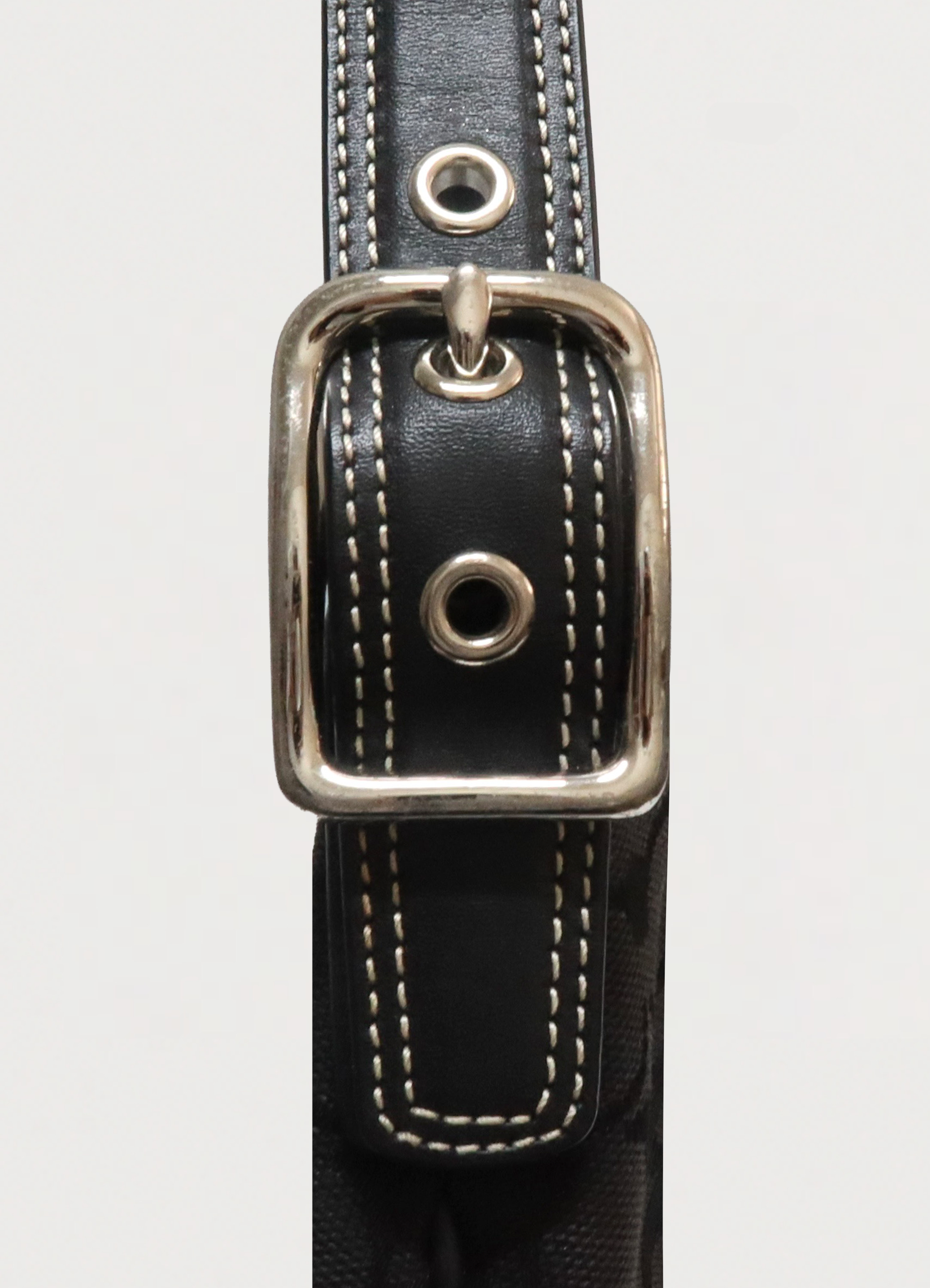 Side view detail of polished silver hardware and leather trim on Coach bag