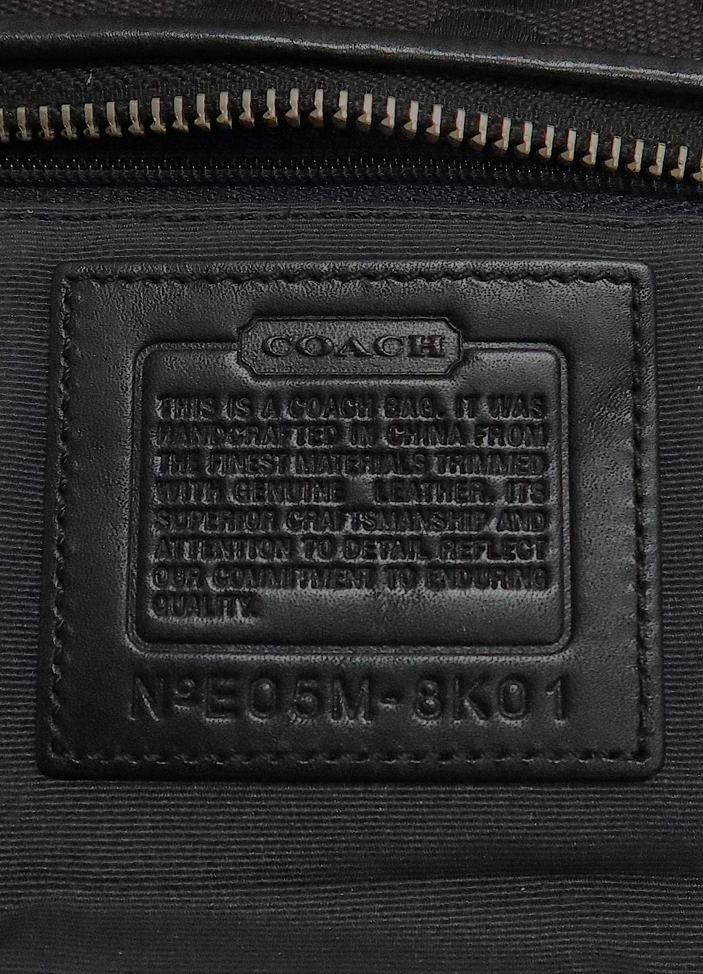 Interior leather Coach creed patch showing serial number for authenticity
