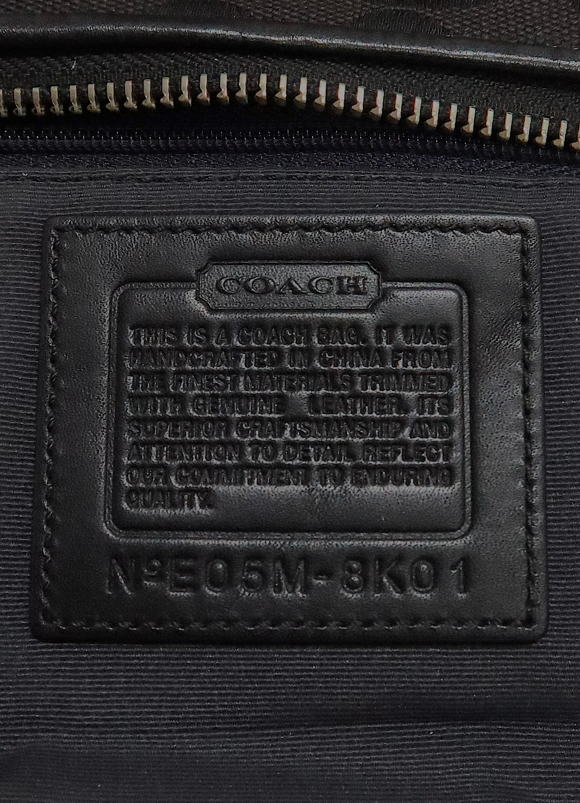 Interior leather Coach creed patch showing serial number for authenticity