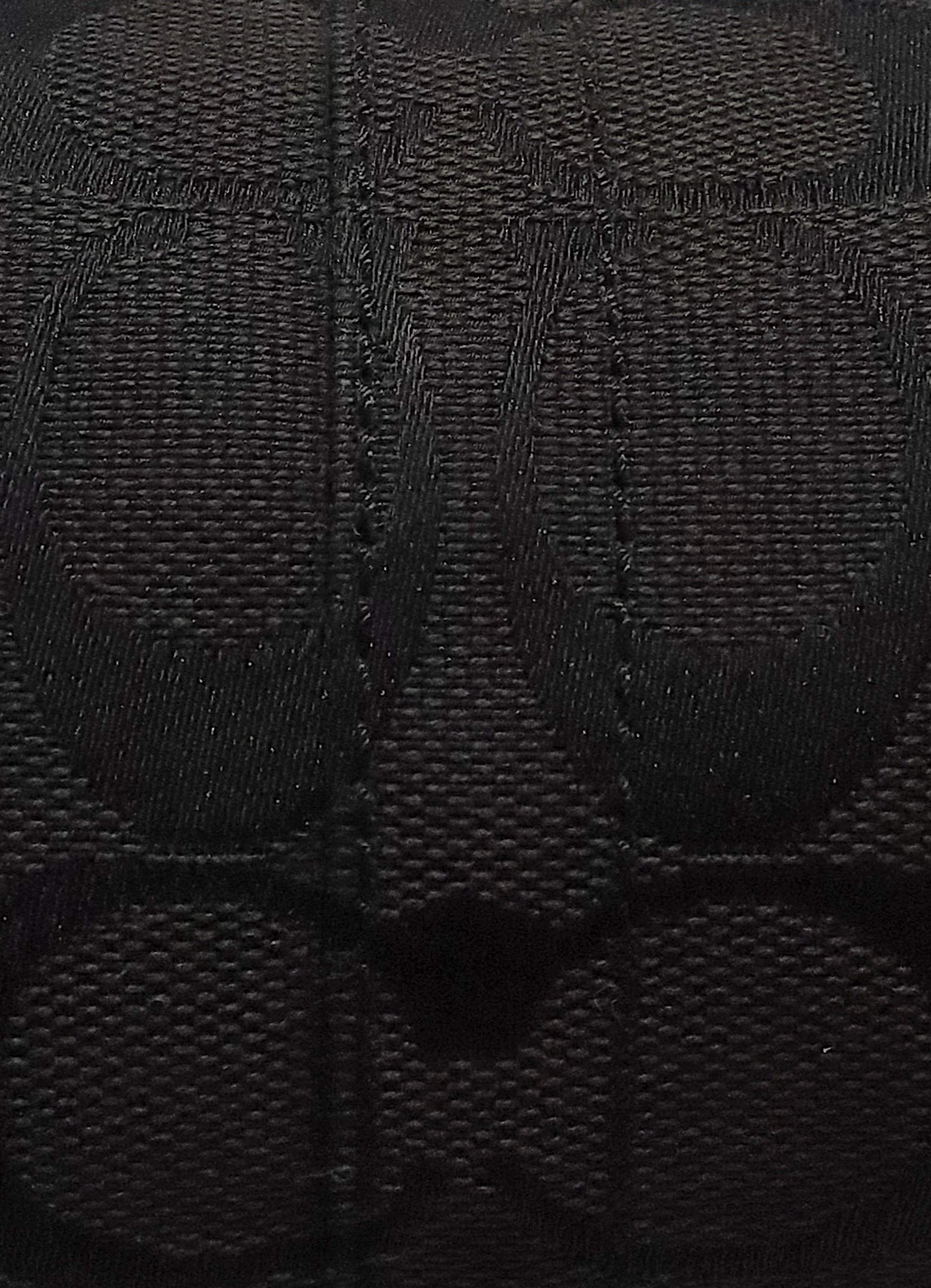 Close up of authentic black Coach signature "C" monogram jacquard canvas