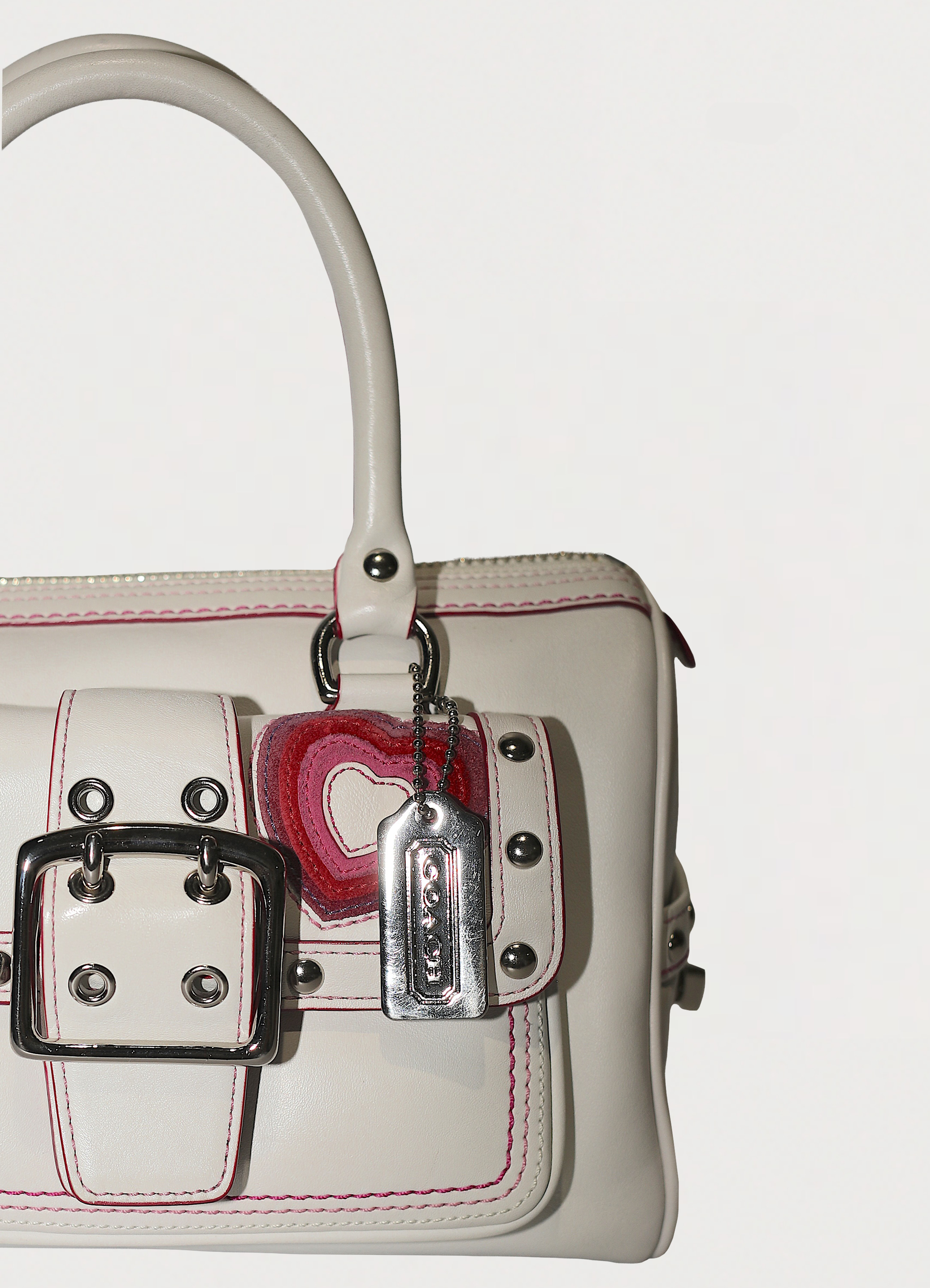 Vintage Coach embroidered heart satchel in leather with suede trim showing close up of hang tag