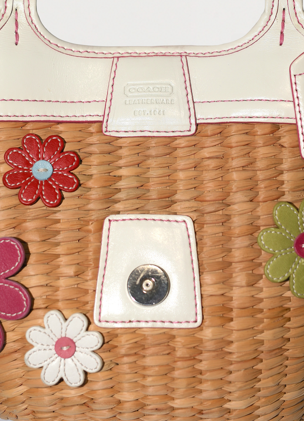 Vintage Coach Flowered straw handbag in white leather trim showing close up of embossed label