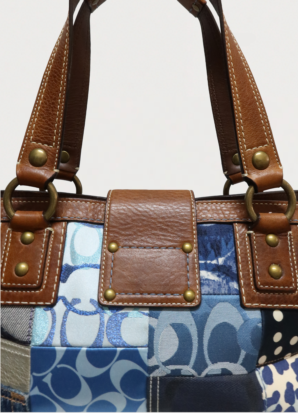 Rear view of the top leather flap and strap attachment on Coach Hamptons satchel