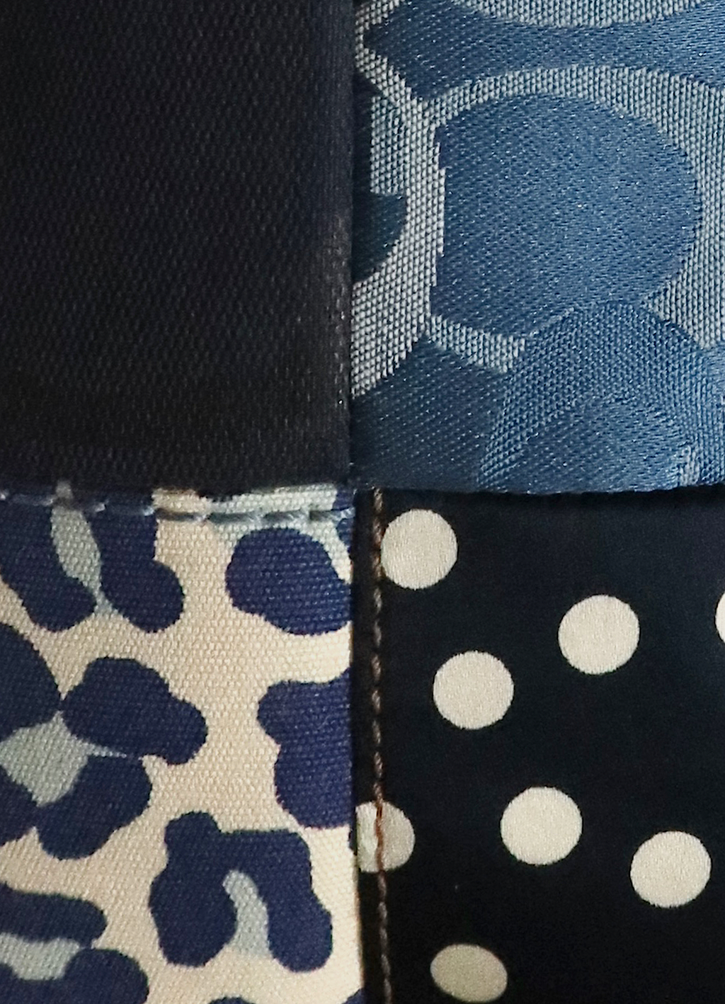 Detail shot of leopard print, polka dot, and signature "C" denim patchwork panels