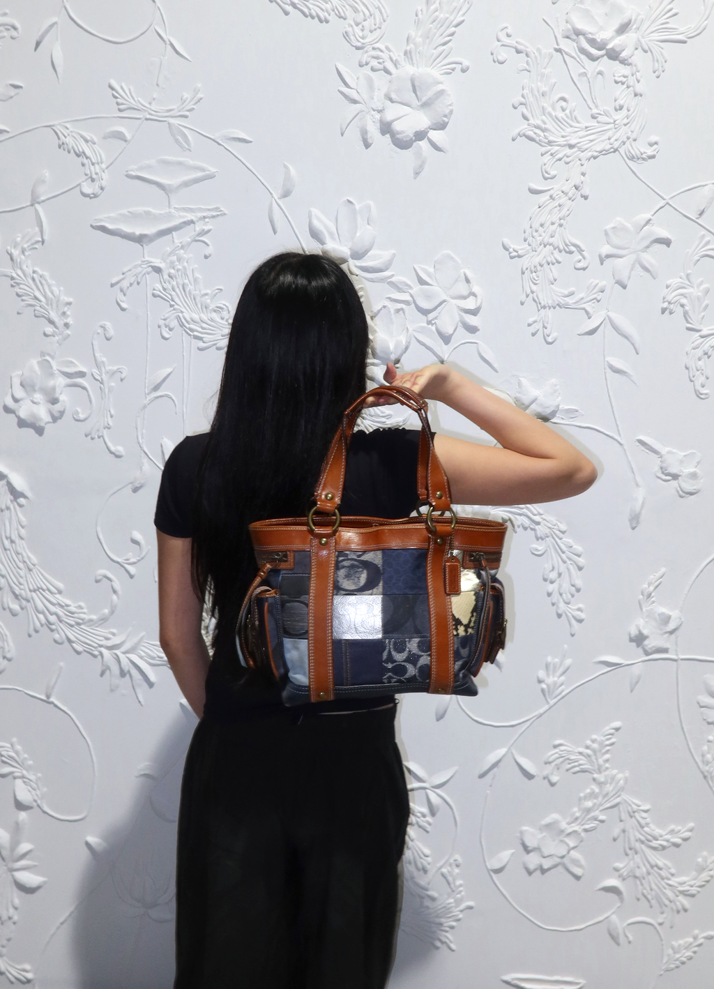 Coach Legacy denim patchwork tote bag held by model