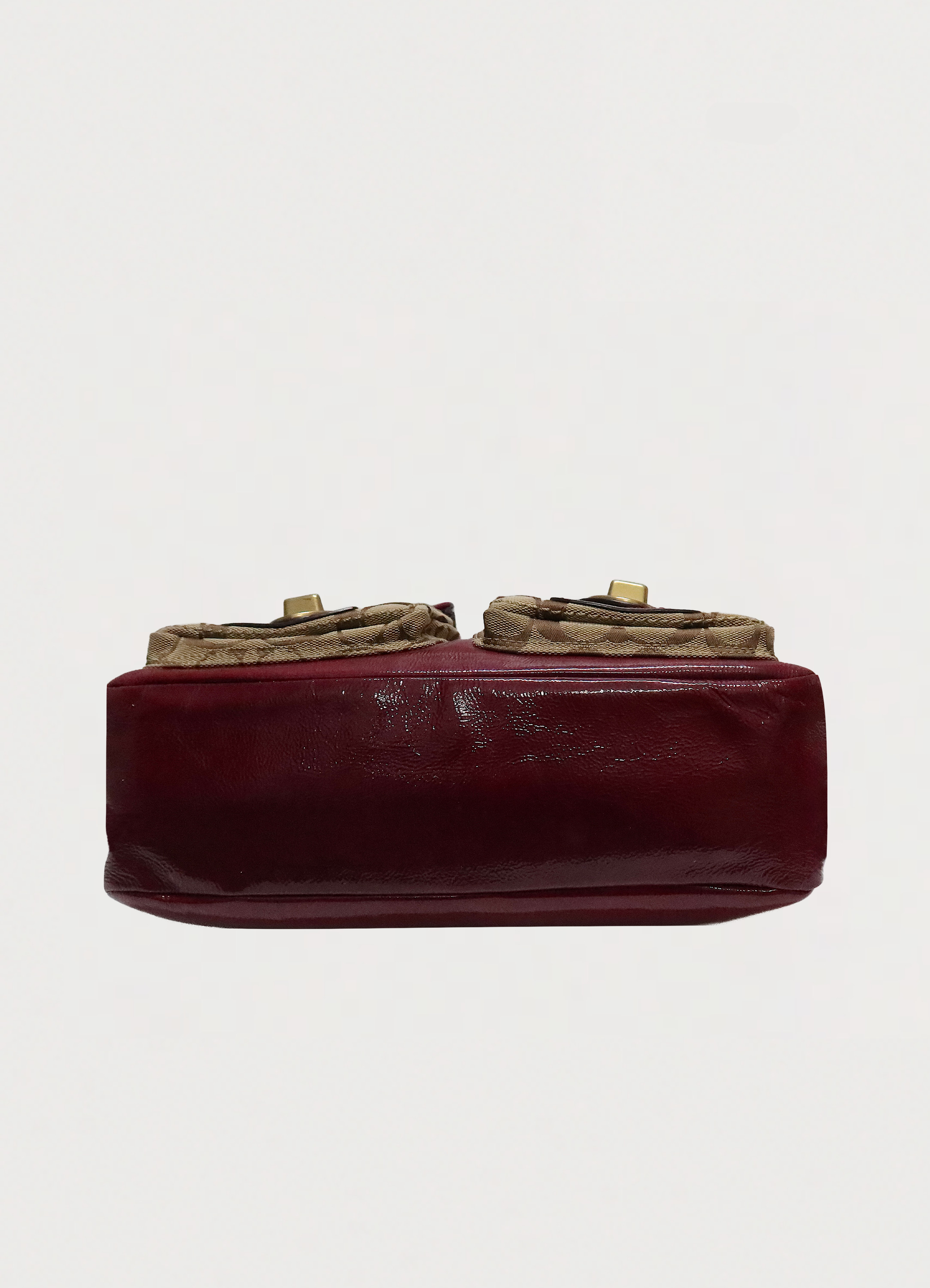 Base view of Coach Legacy turnlock pouch showing beet red leather bottom
