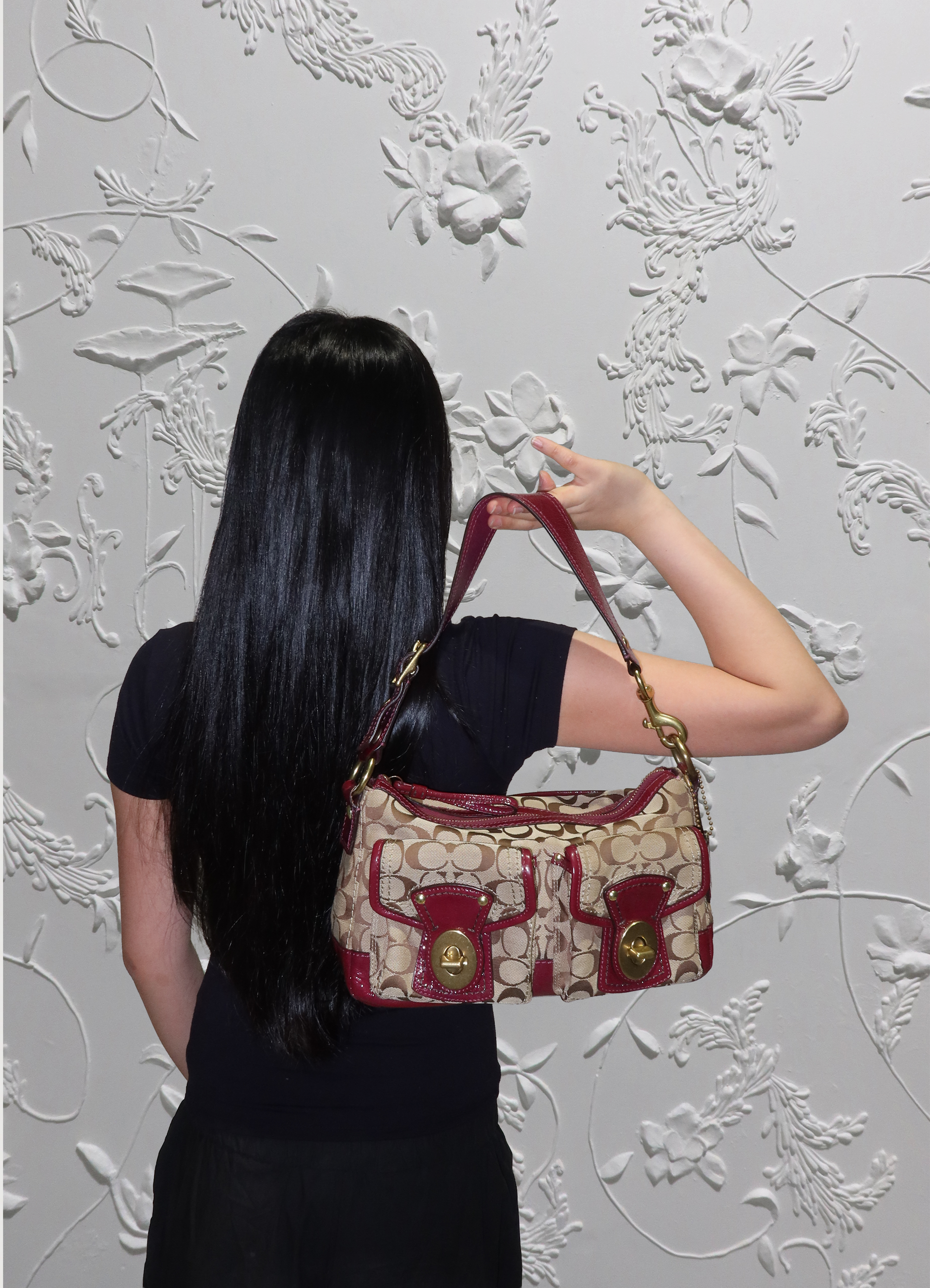 Coach Legacy turnlock pouch bag held by model