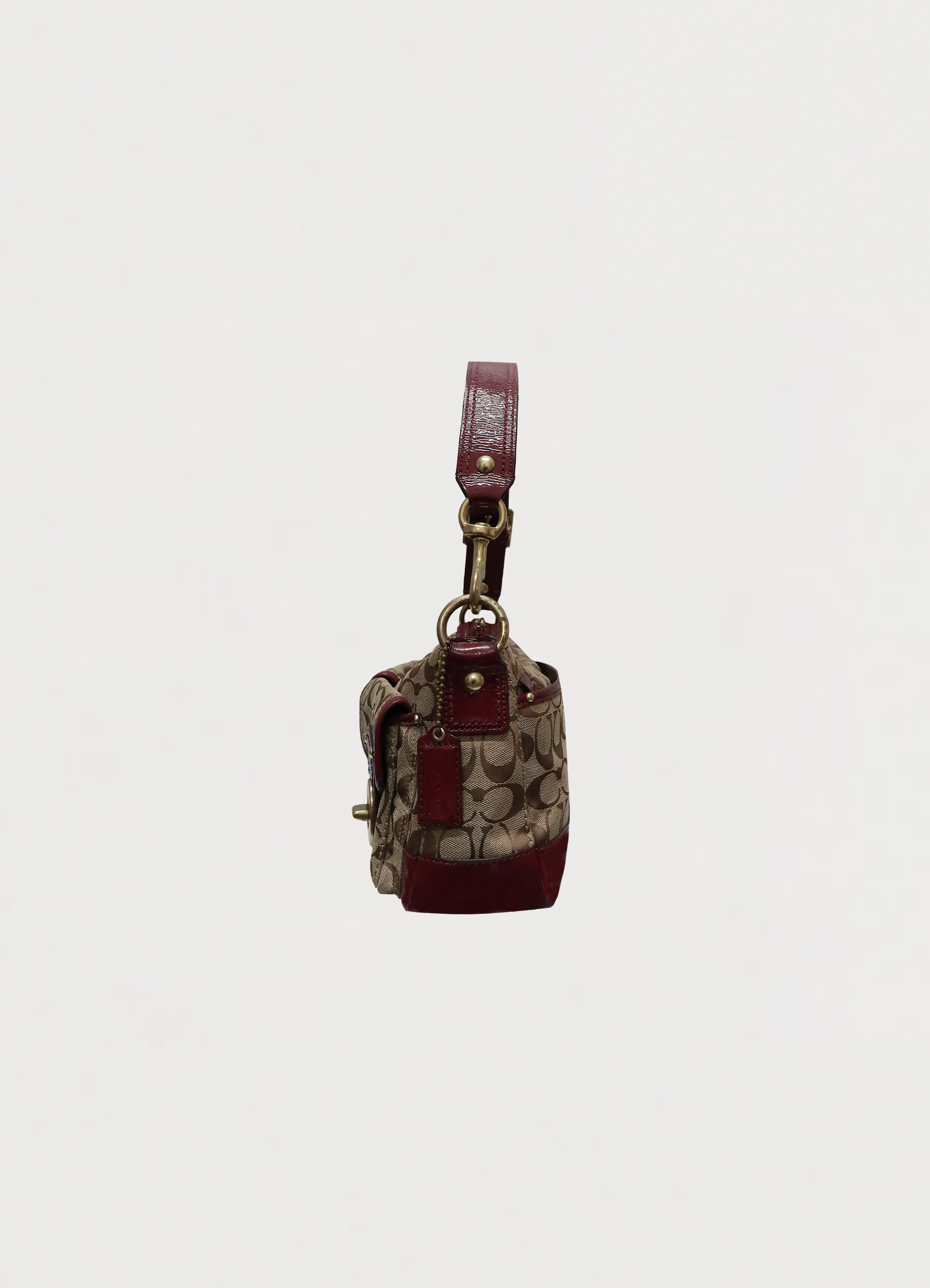 Right side profile of khaki Coach Legacy turnlock baguette bag