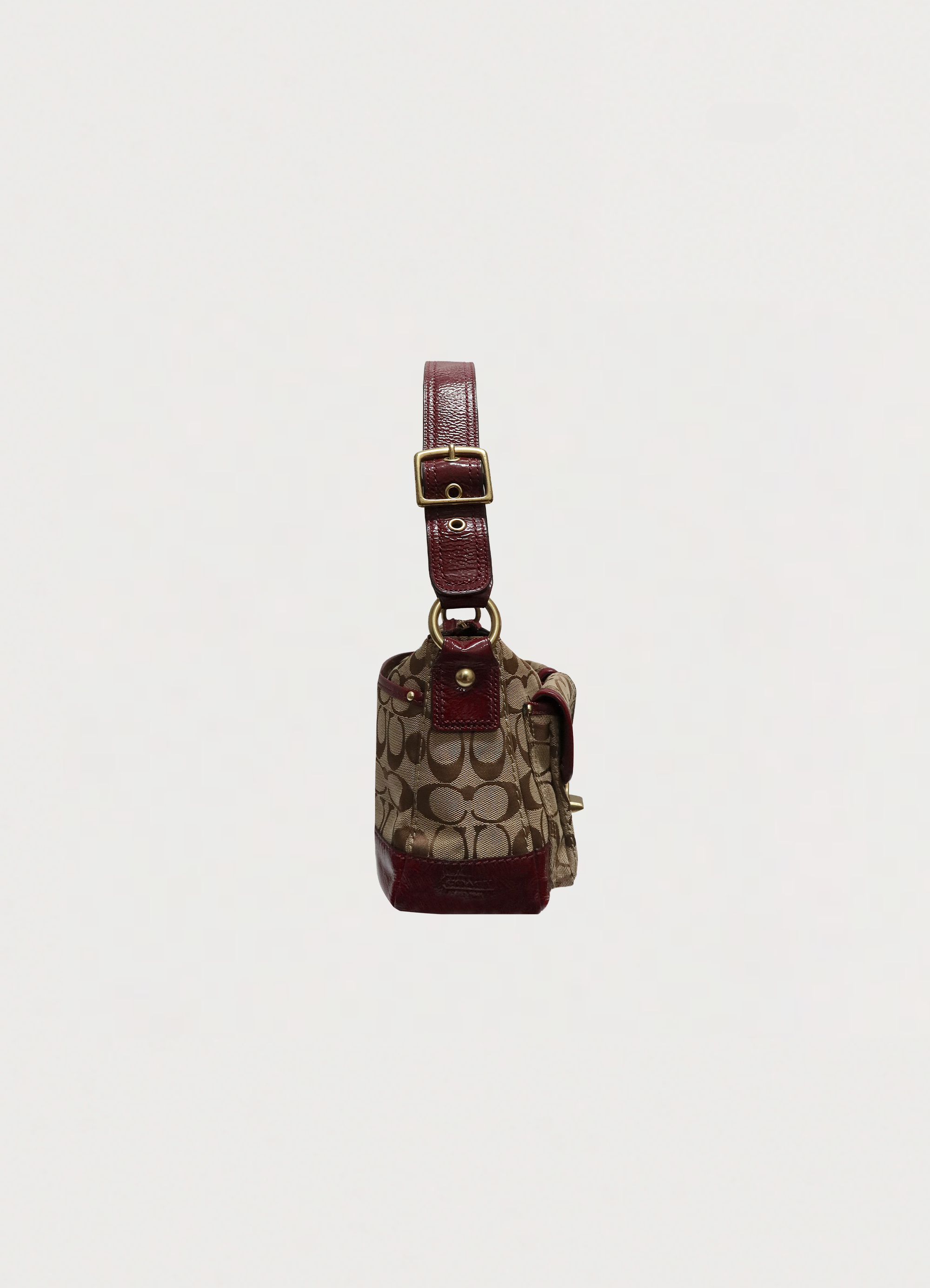Left side profile of khaki Coach Legacy turnlock baguette bag