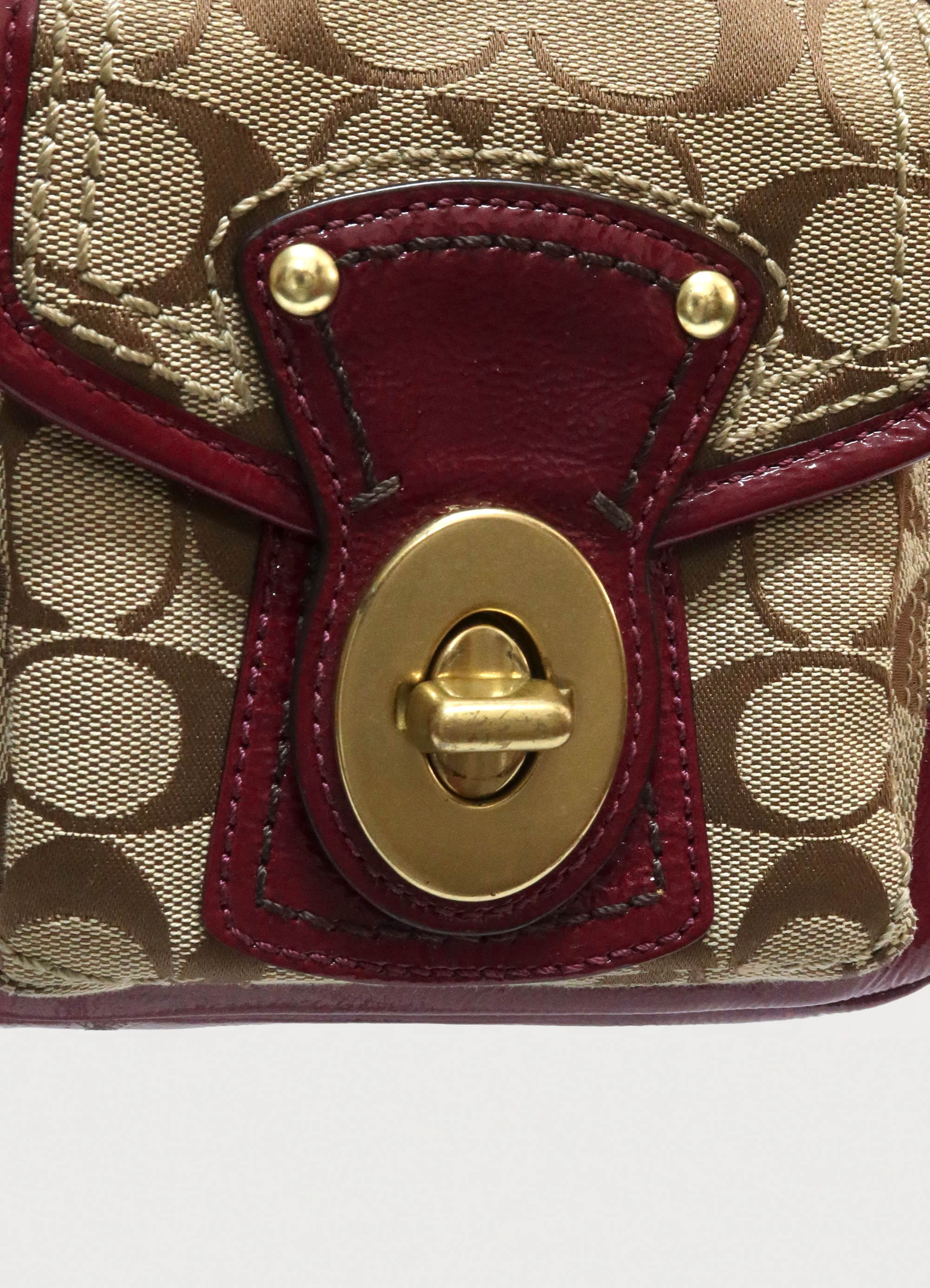 Detailed shot of beet red leather flap and brass turnlock closure