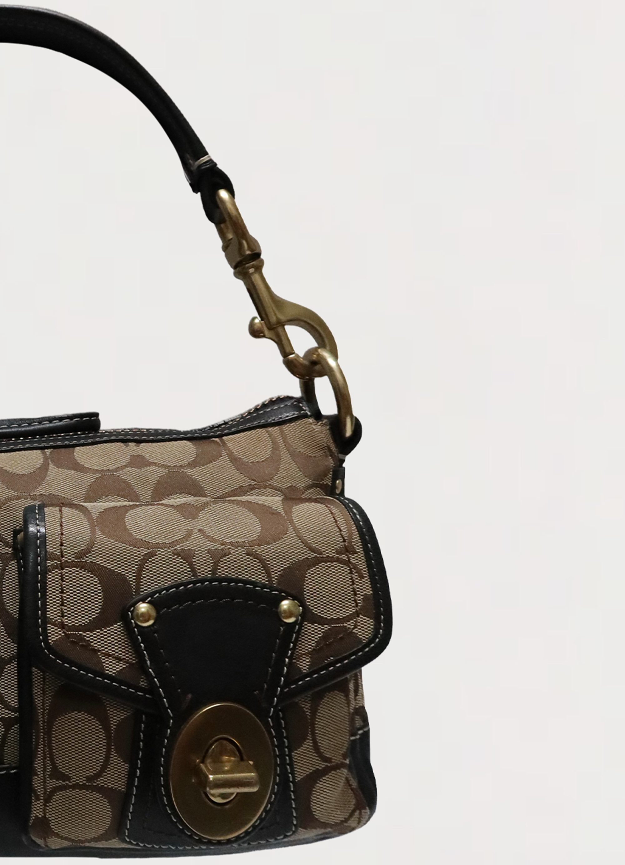 Close up of the front flap pocket with brass turnlock closure and ebony leather trim on Coach Legacy satchel.