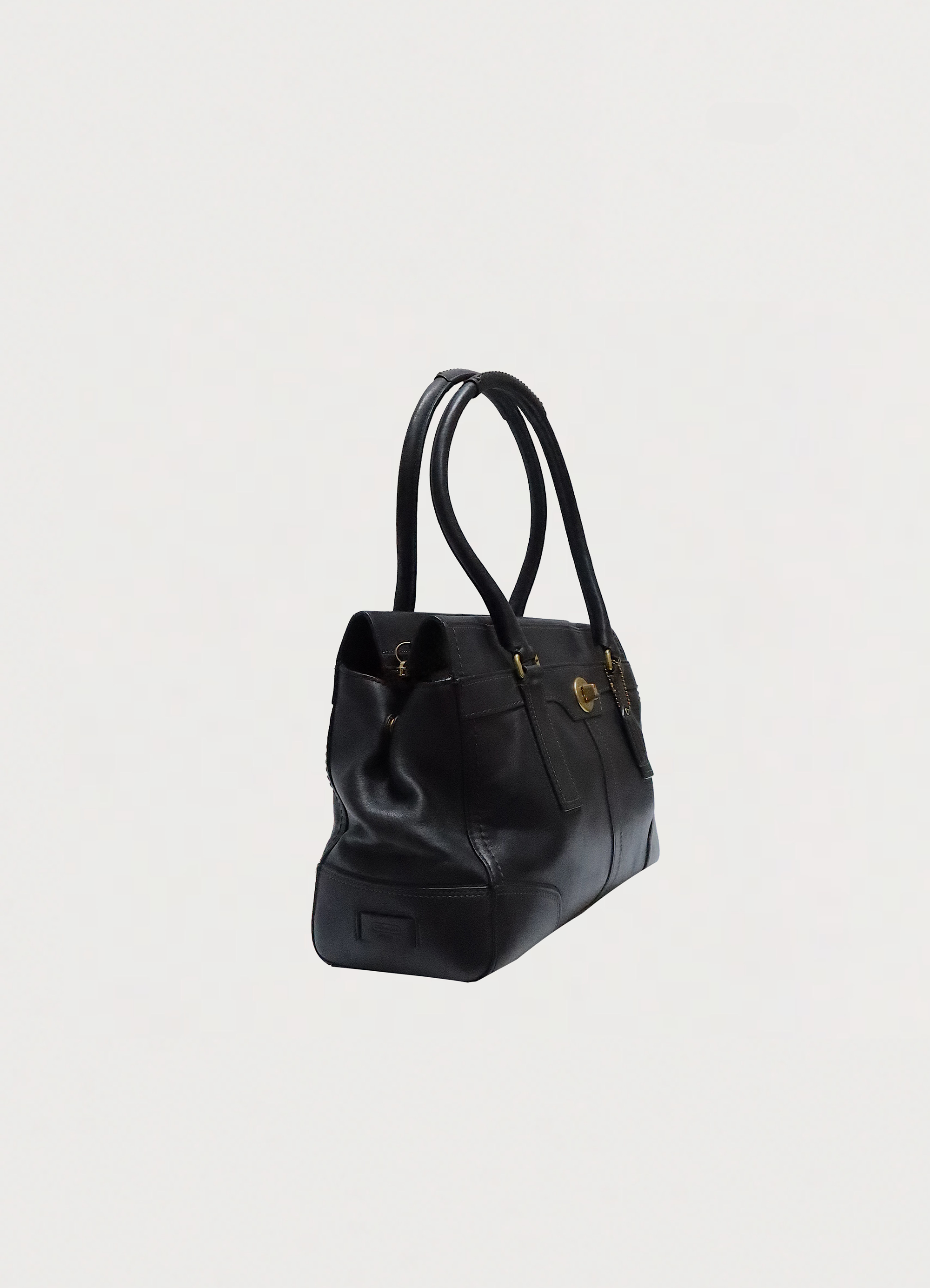 Angled side view of Coach Madeline black leather bag showing structured shape