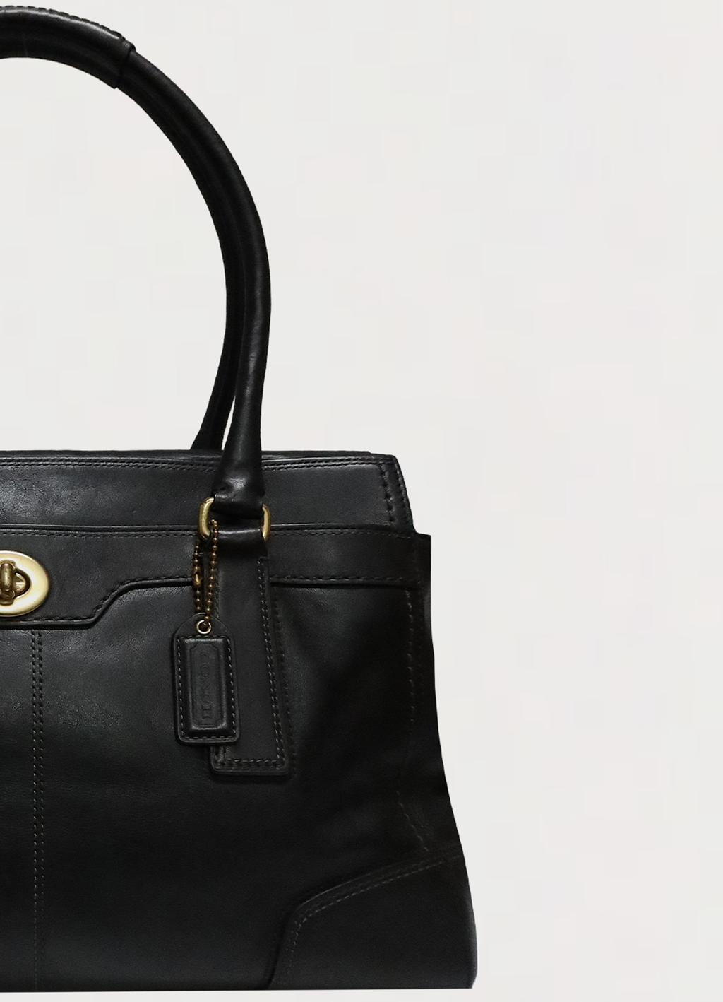 Close up of brass hardware and handle attachment on Coach Madeline bag