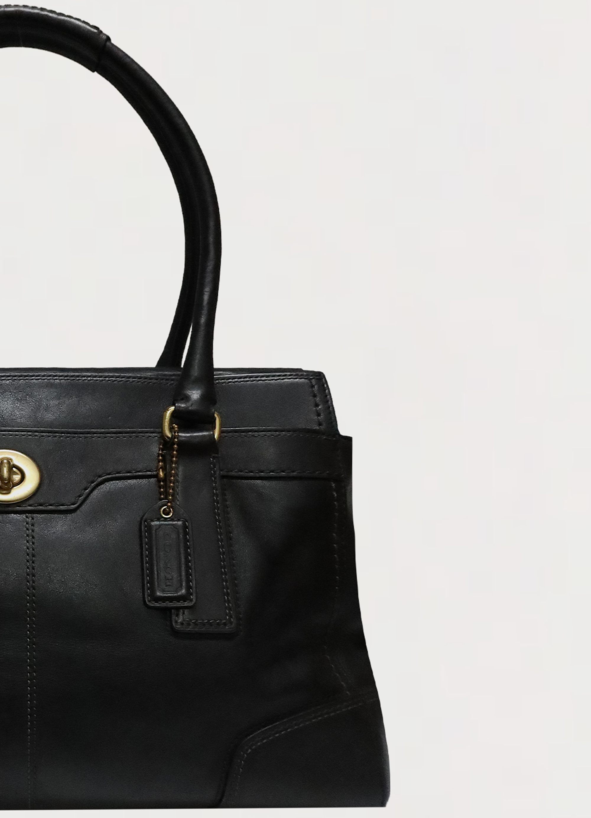Close up of brass hardware and handle attachment on Coach Madeline bag