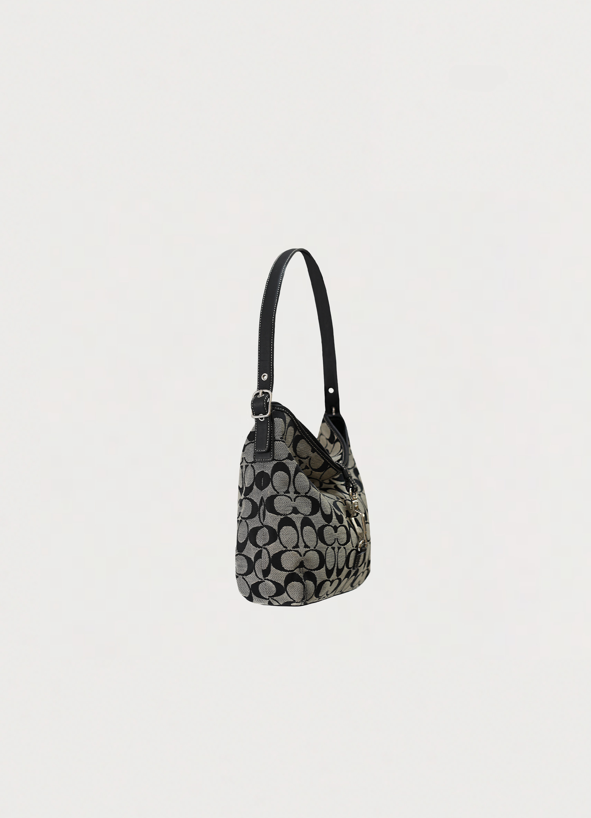 Angled side view of Coach black signature hobo bag showing bag depth