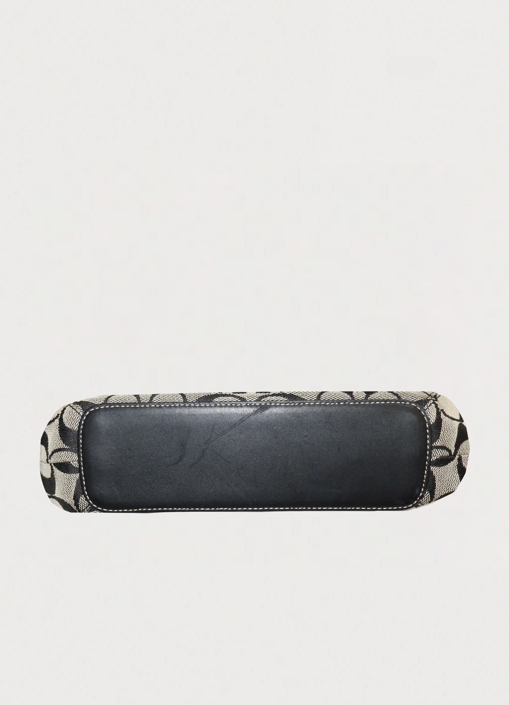 Detailed bottom view of the Coach hobo bag showing black leather bottom