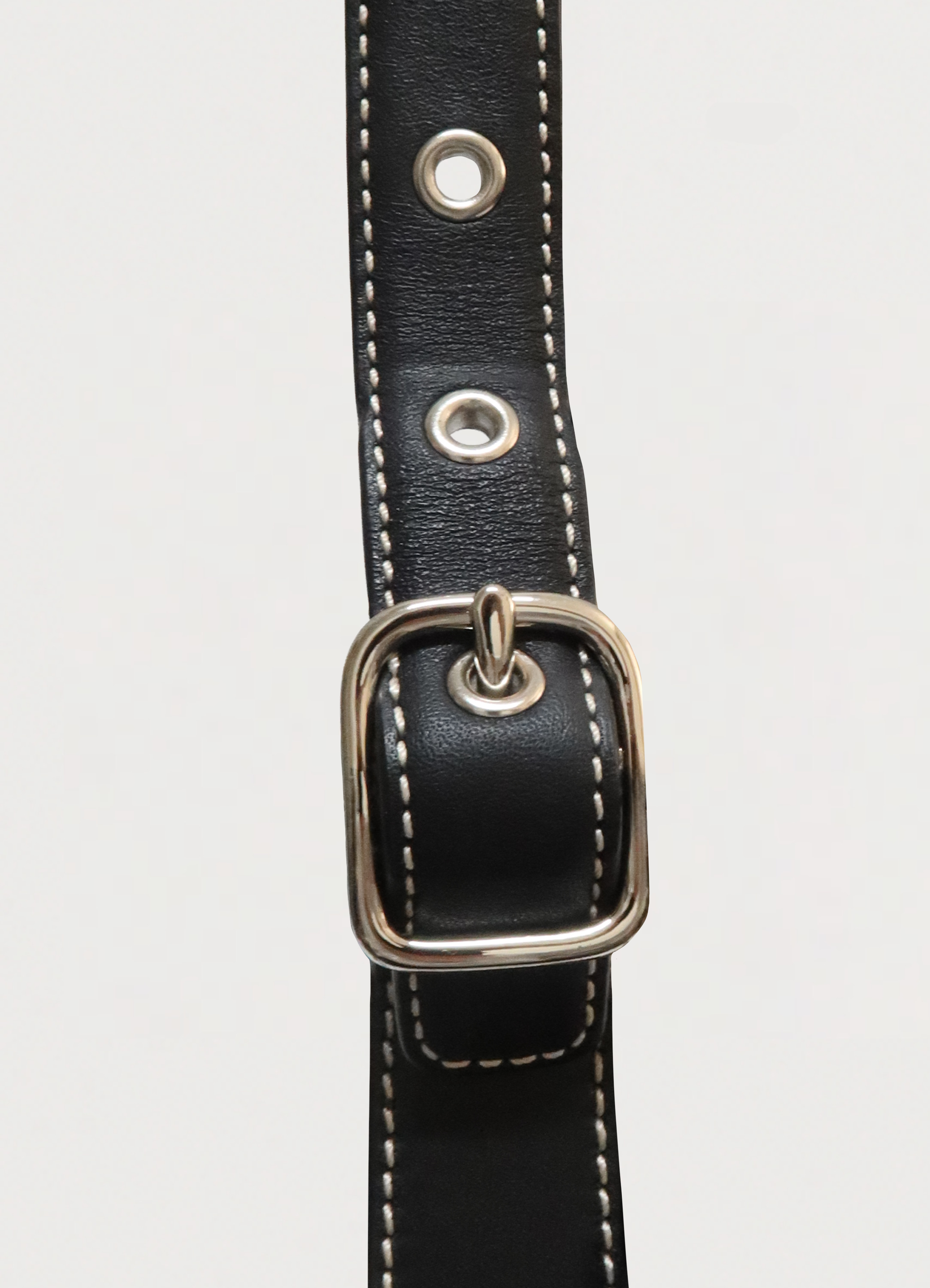 Side view of the polished silver buckle hardware on the black leather strap