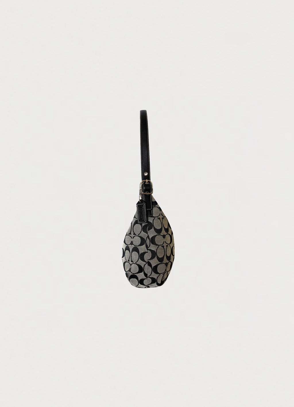 Left side profile of black and grey Coach Signature clip hobo bag