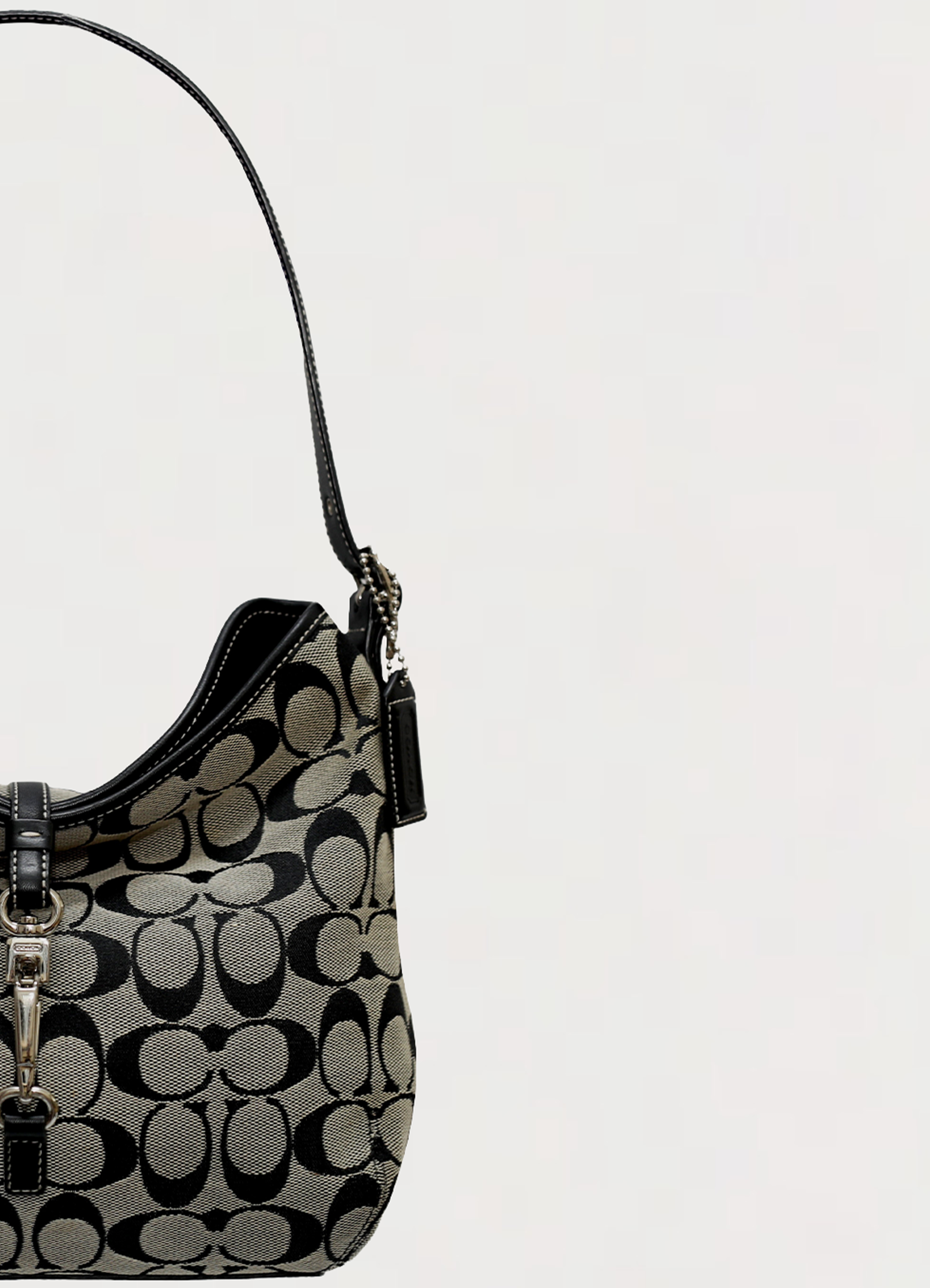 Close up of the black leather shoulder strap and hardware on Coach hobo bag